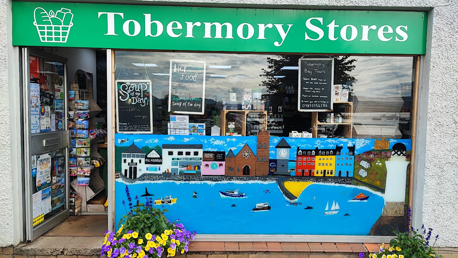 The green 'Tobermory Stores' sign over the shop window, a painted mural below.