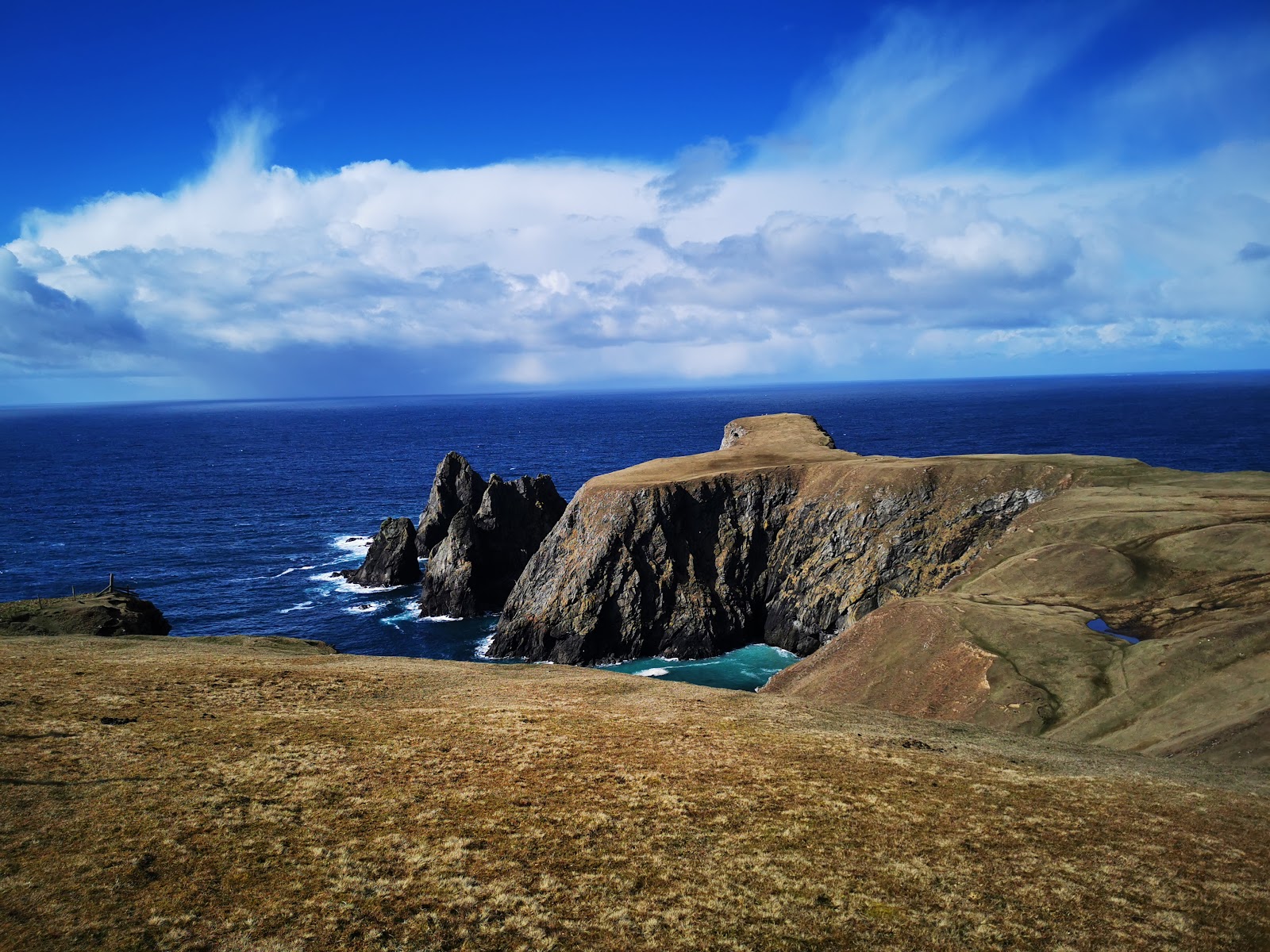 Headlands and sea stacks on the coast by the Dale of Walls under a blue sky.