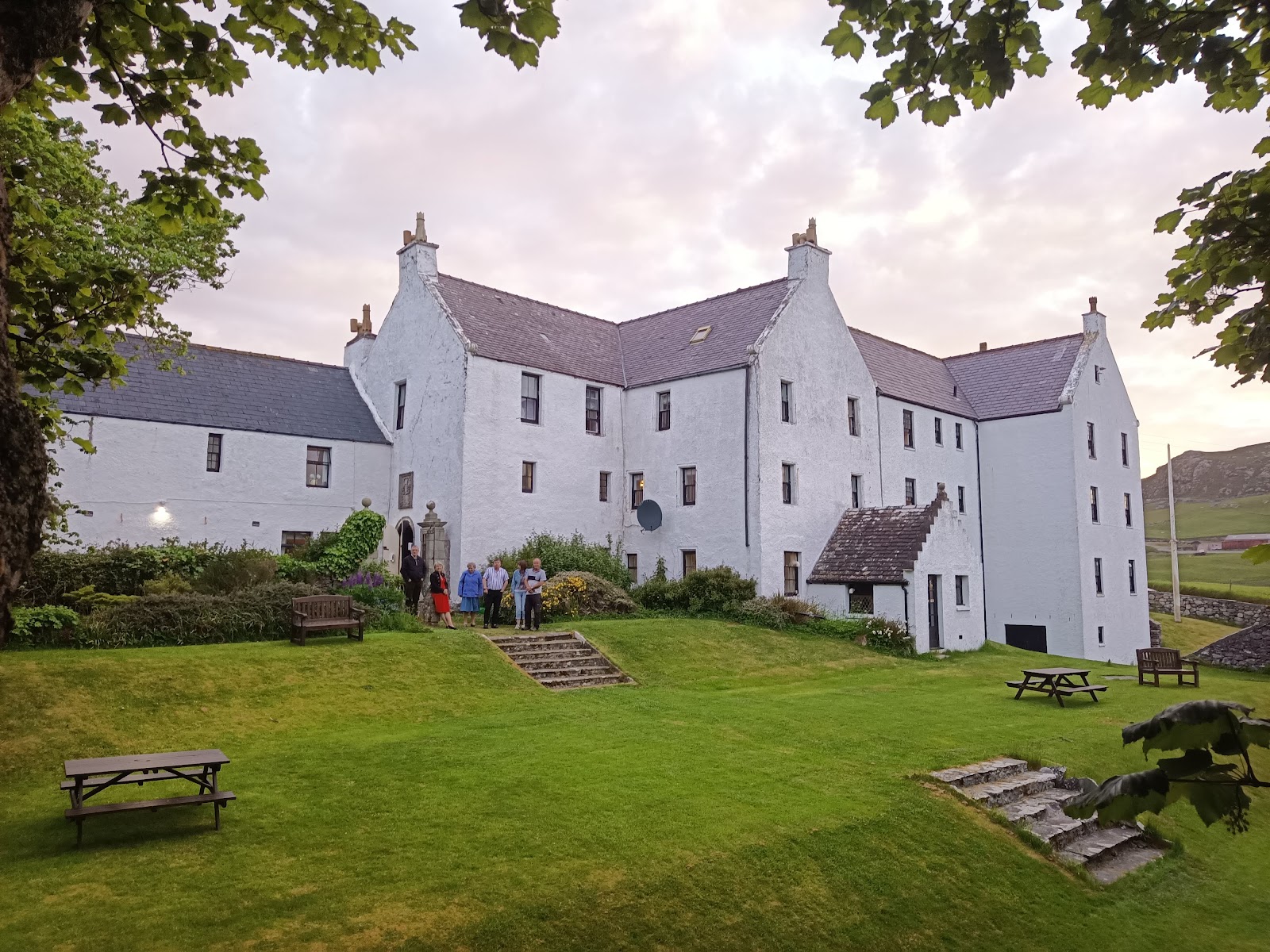 Busta House's white-harled front and gable ends above its lawn, Brae.