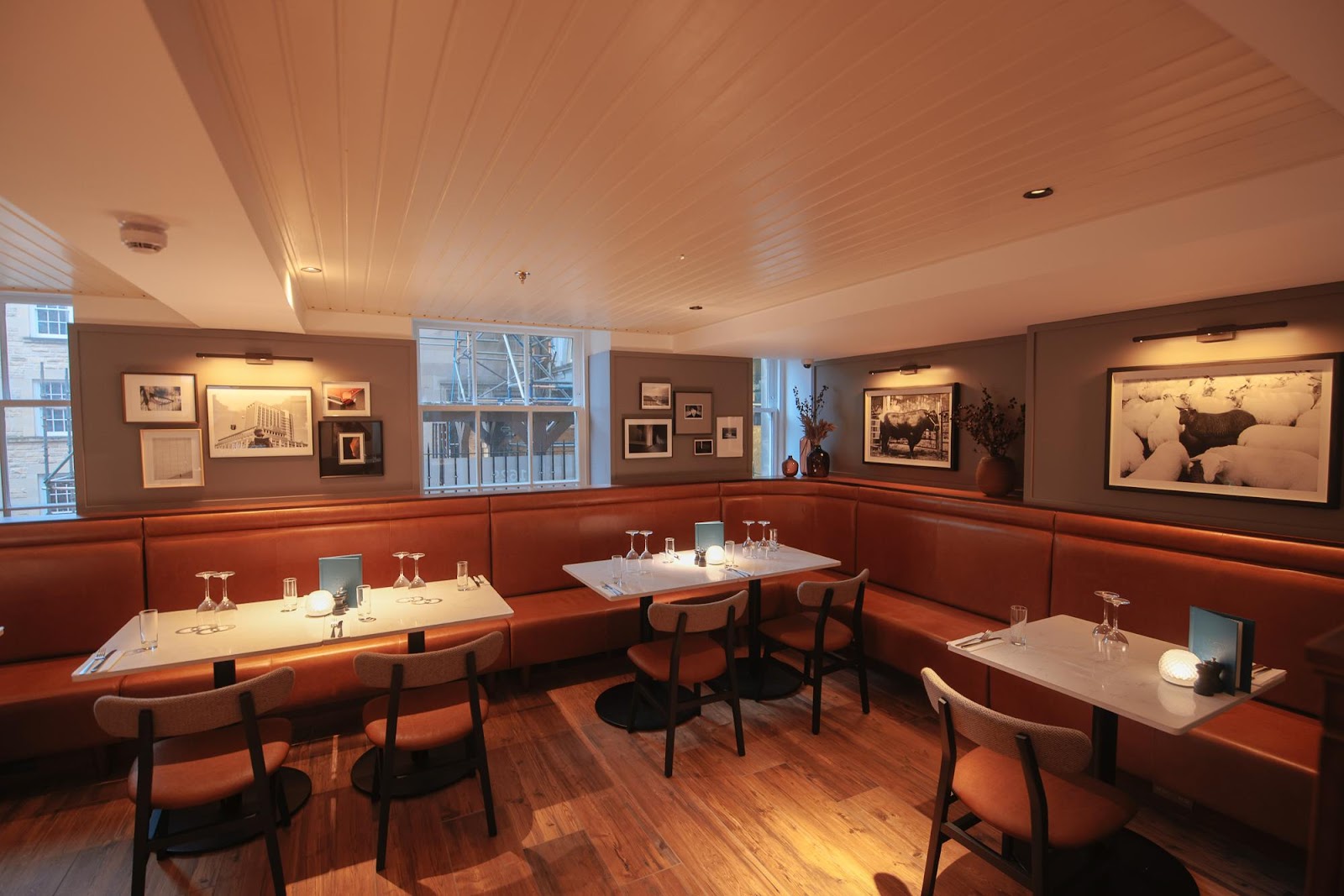 The dining room at Luckenbooths, leather banquettes and framed pictures under warm light.