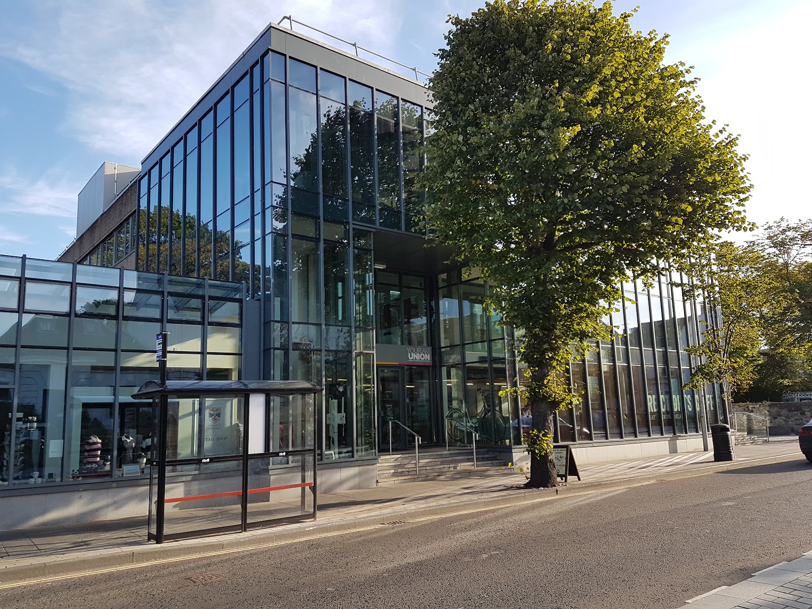 Glass-fronted students' union building with "Your Union" sign beside a bus stop