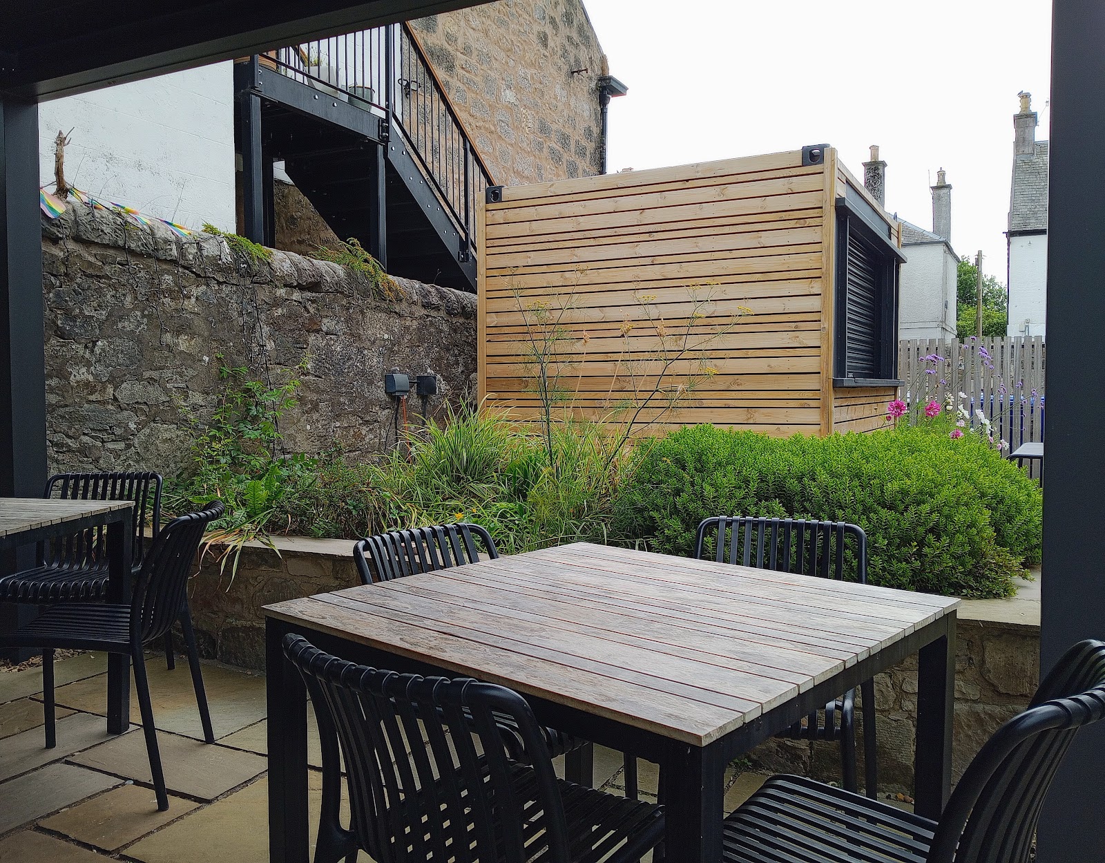 The bookshop's courtyard with tables and a timber shelter.