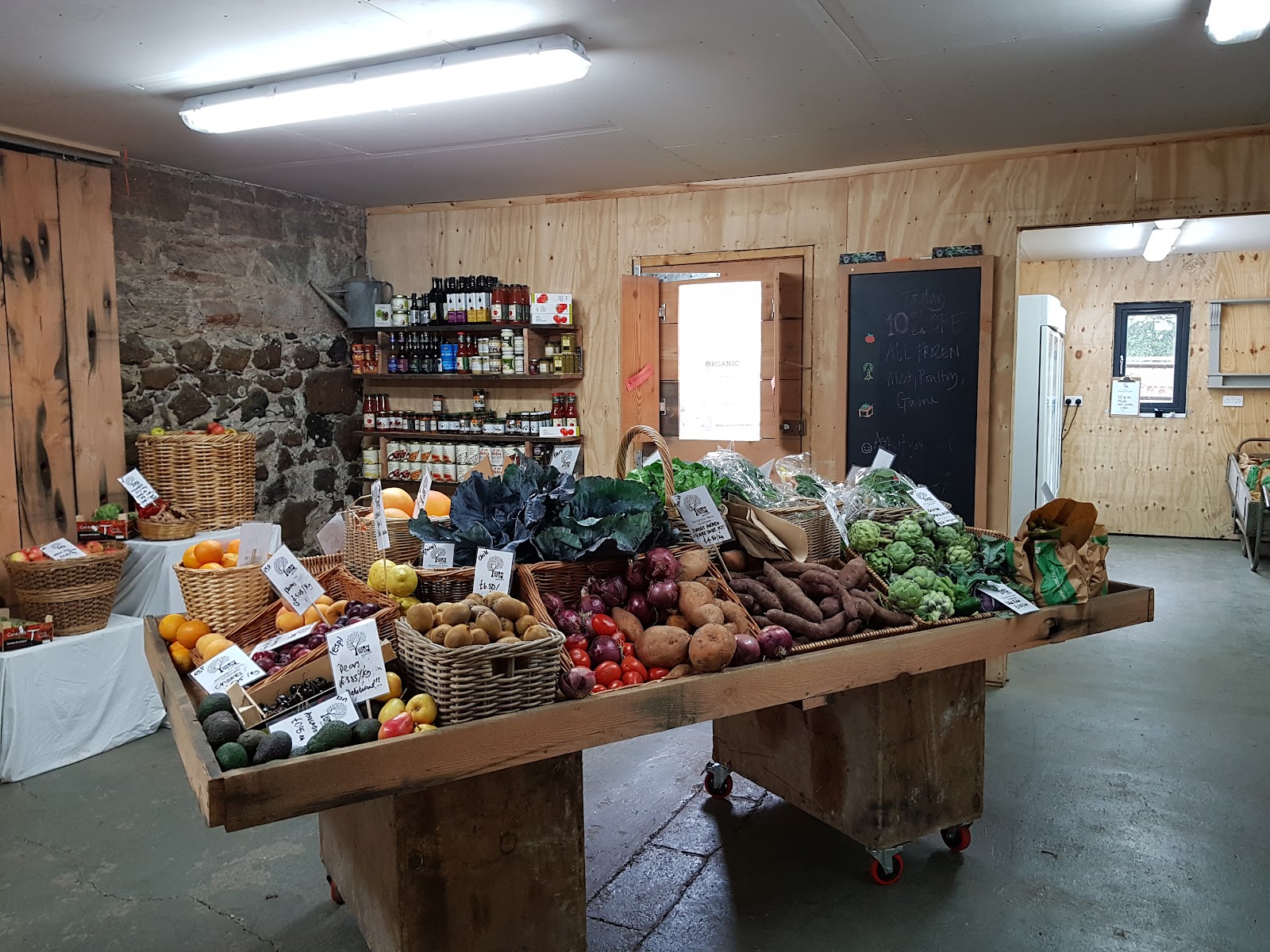 The farm shop at Grow Wild near Linlithgow, a wooden table heaped with vegetables and fruit.