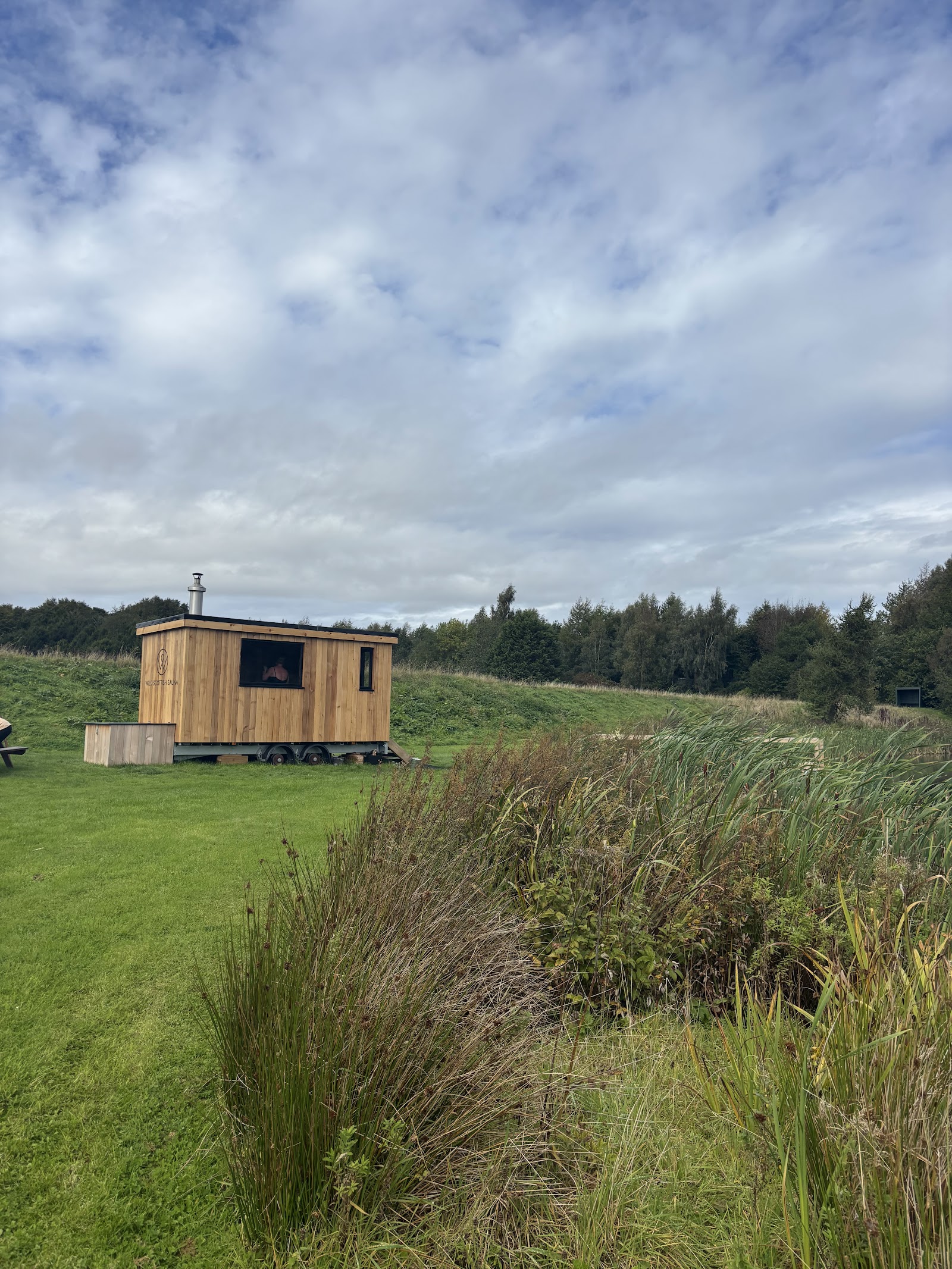 The timber sauna hut beside reeds and water at Forbes of Kingennie.