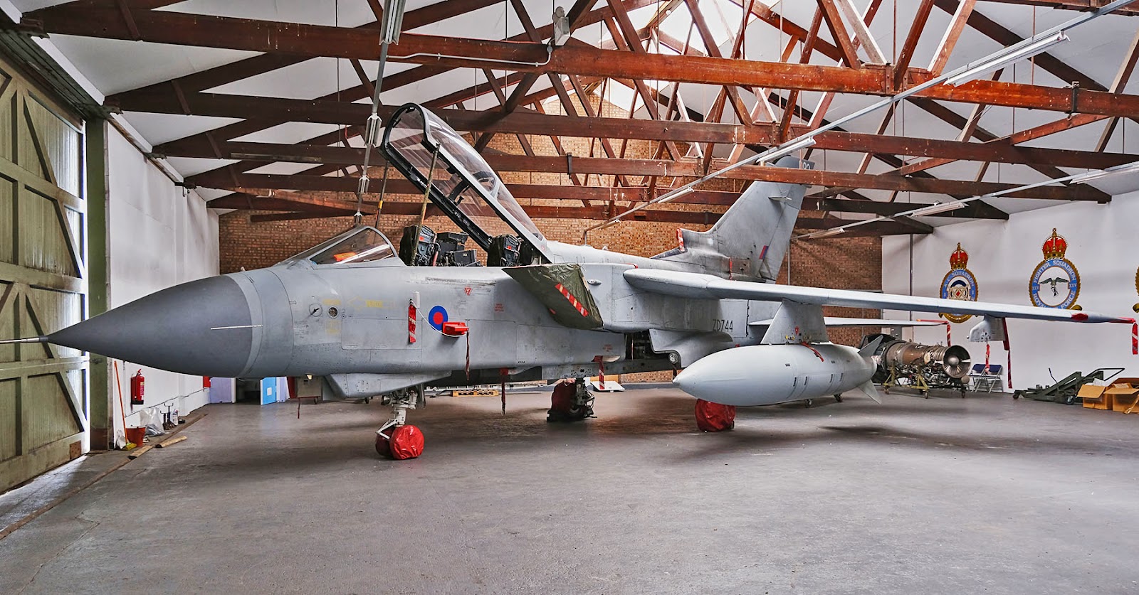 RAF Tornado ZD744 stored in a hangar with squadron crests on the wall