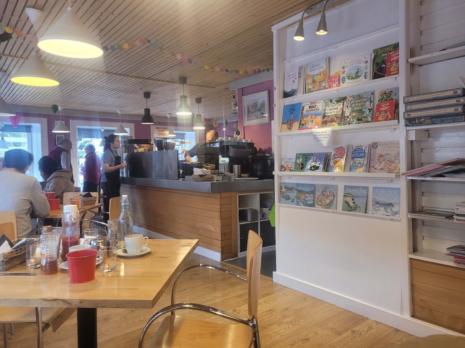 Inside Ben Lora, the café counter at one end and shelves of books on the wall.