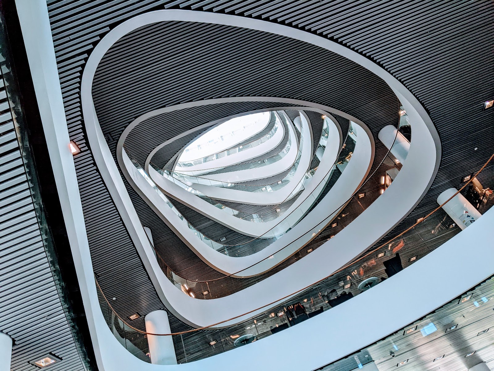 The white spiralling atrium of the Sir Duncan Rice Library, its curving balconies seen from above.