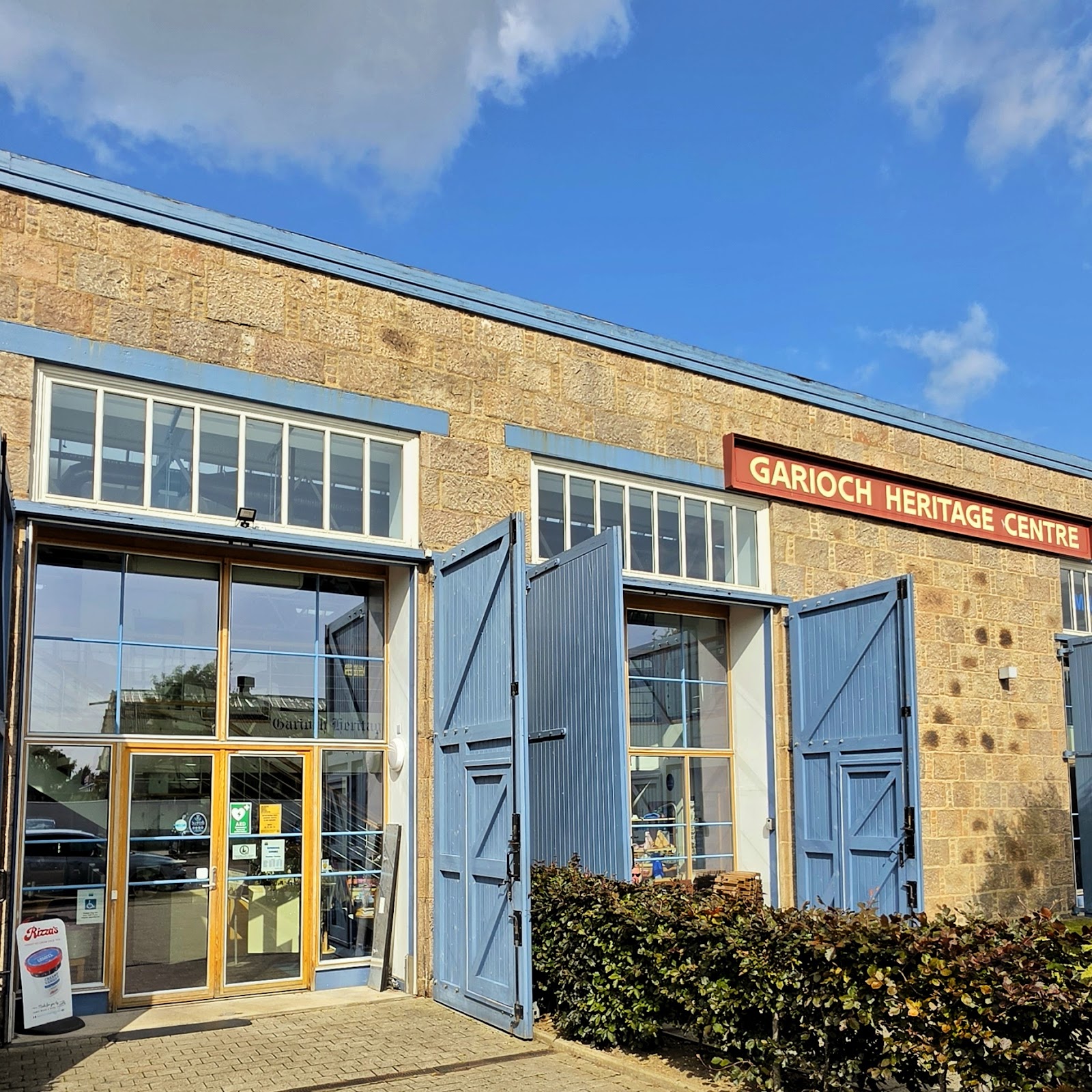 The brick front of the Garioch Heritage Centre with its tall blue doors, in the old locomotive works.