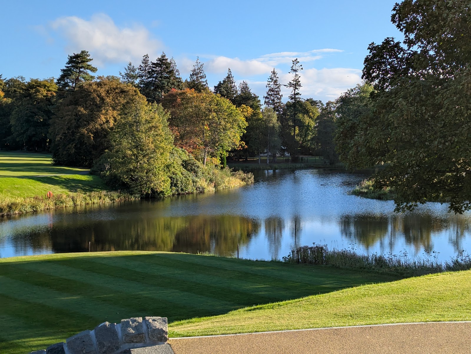 A loch among autumn trees in the grounds of Gleneagles.
