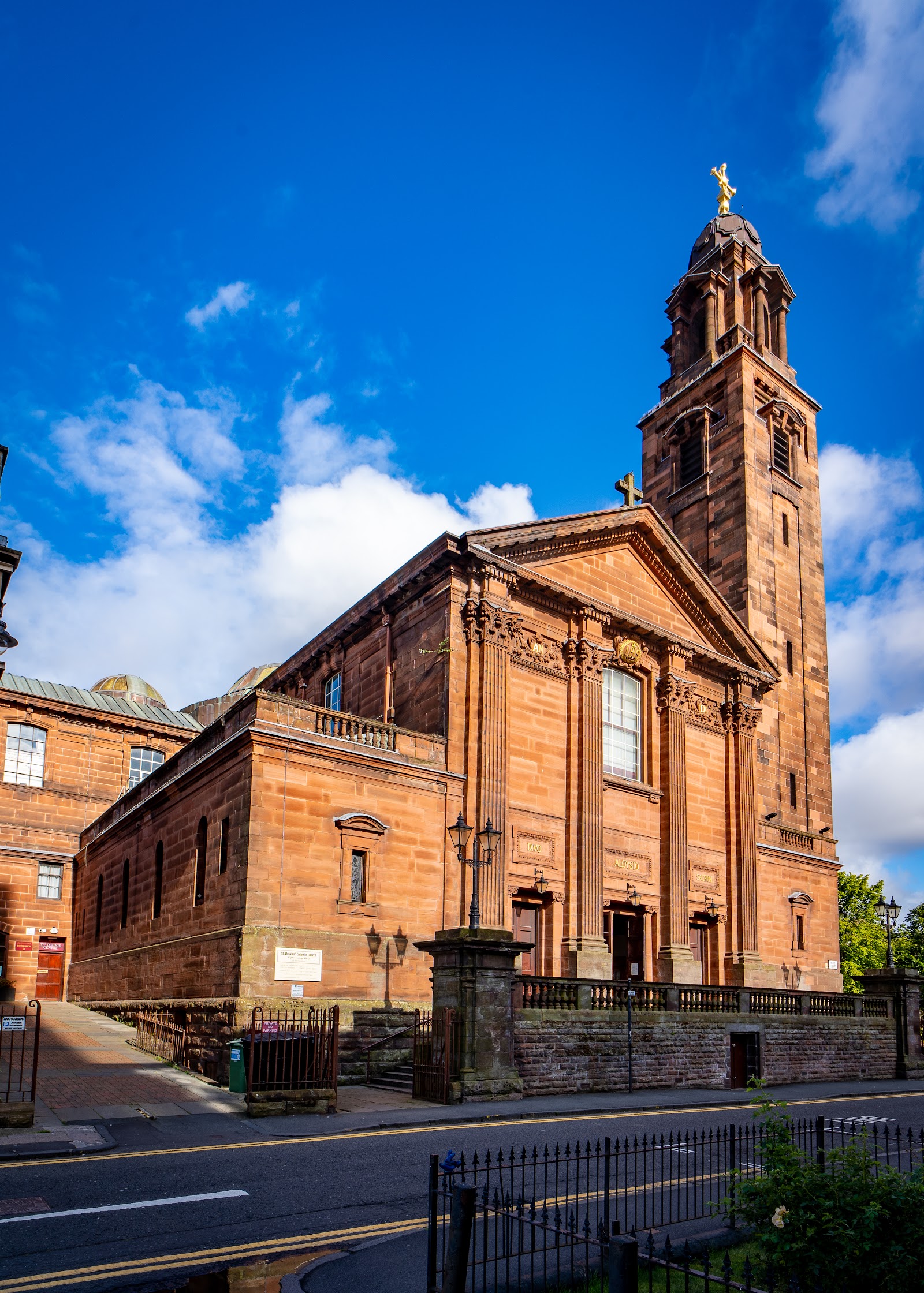St Aloysius Church on Garnethill, its red sandstone front and tall domed campanile under a blue sky.