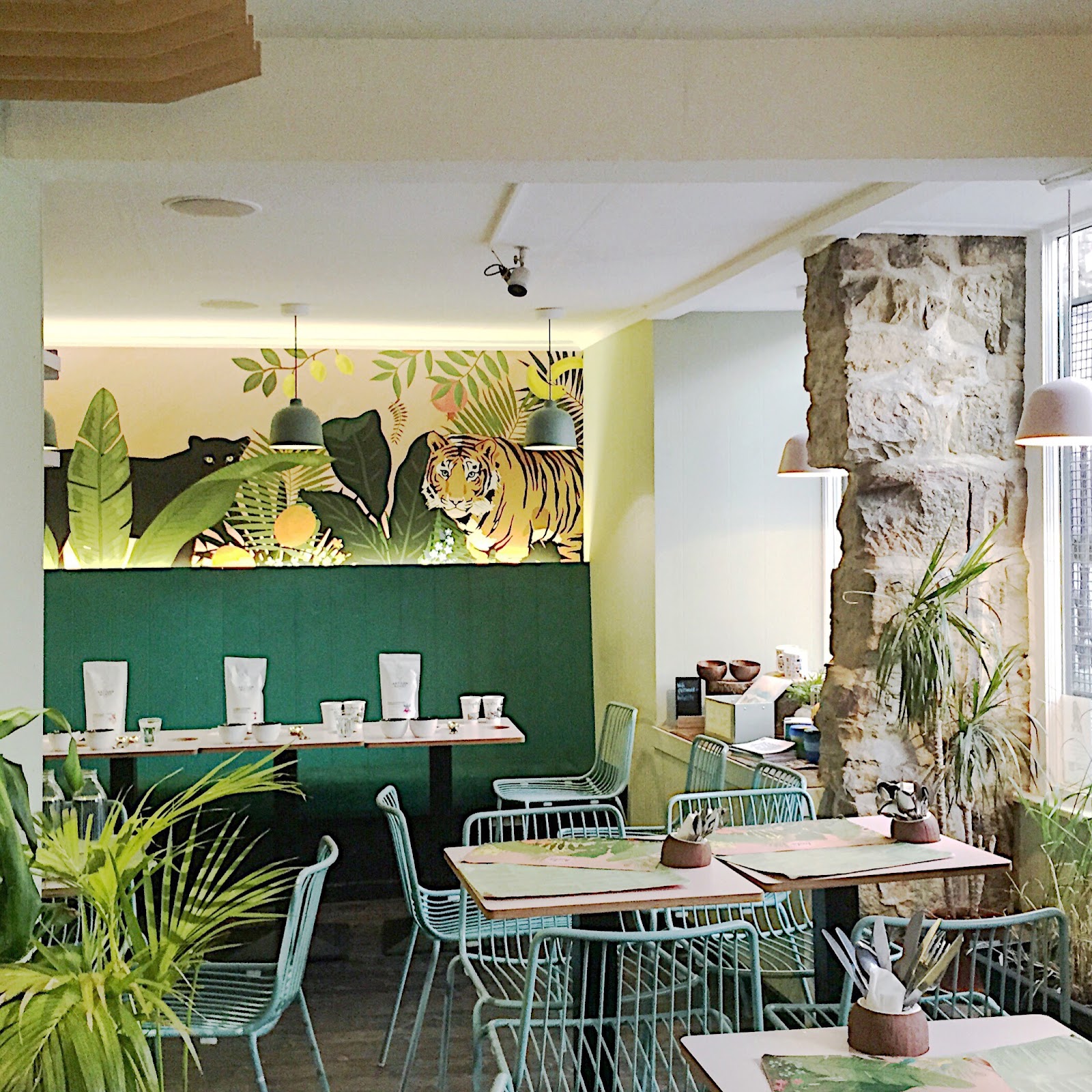 The dining room at Hula, its walls papered with tigers and palm leaves.