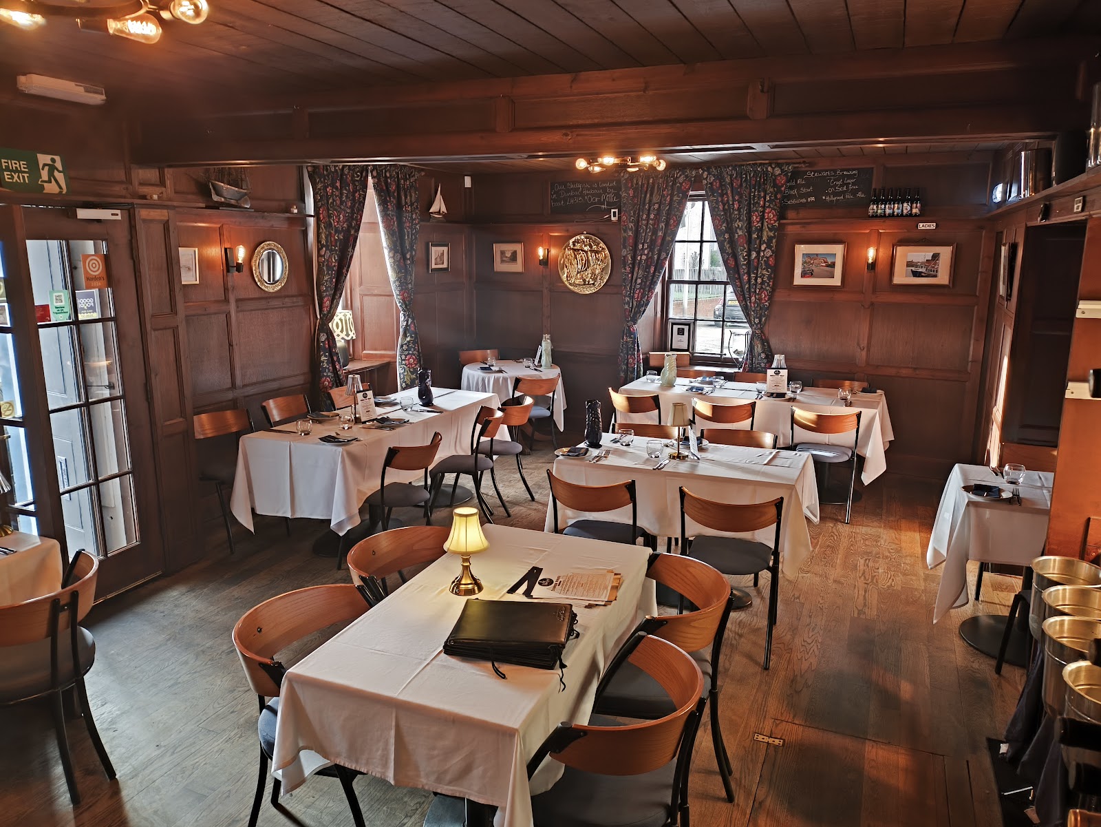 The dining room at the Creel in Dunbar, tables laid with white cloths under old beams.