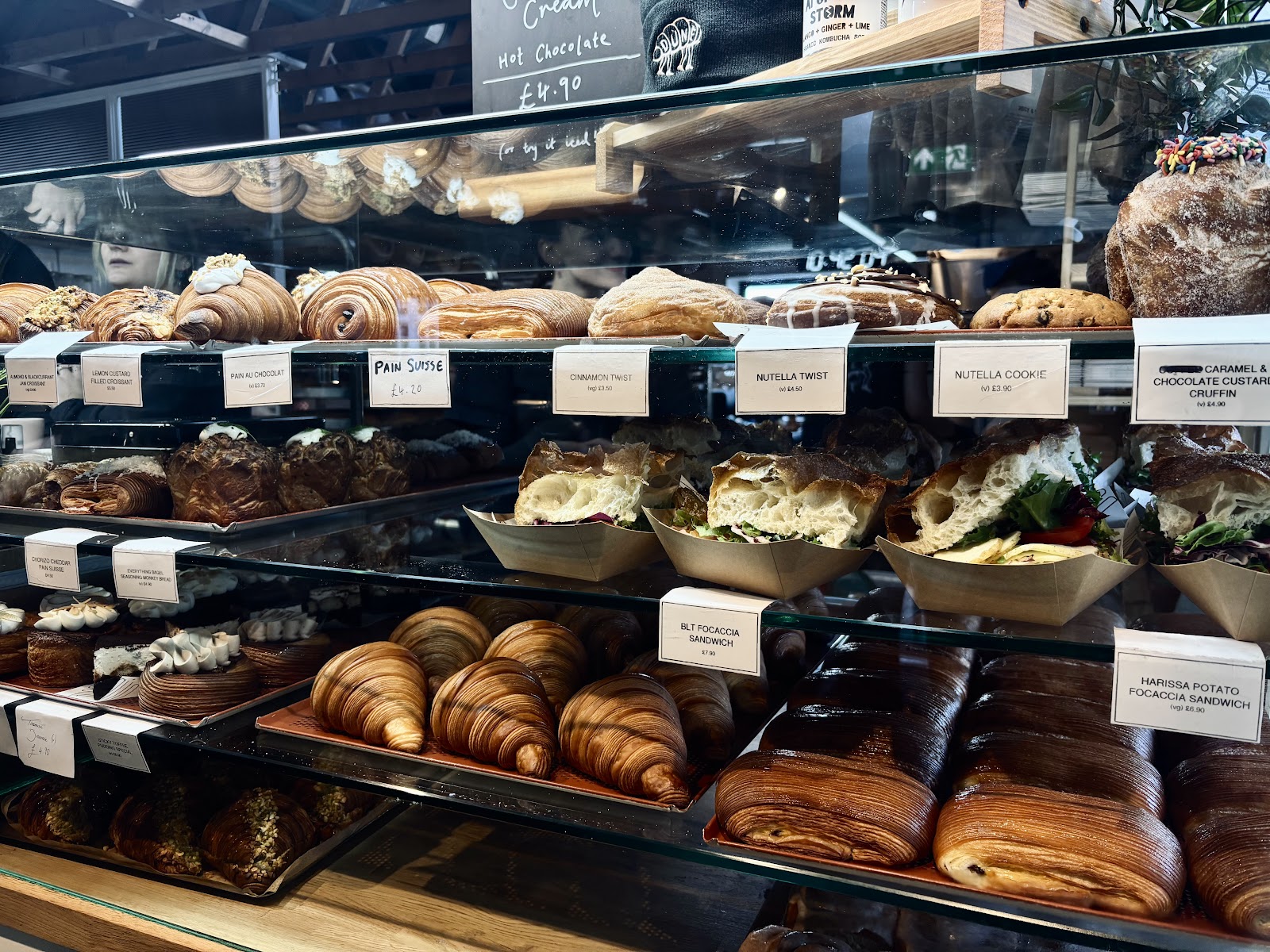 The counter at Dune Bakery in South Queensferry, with croissants, pains au chocolat, twists, cruffins and focaccia sandwiches behind glass.