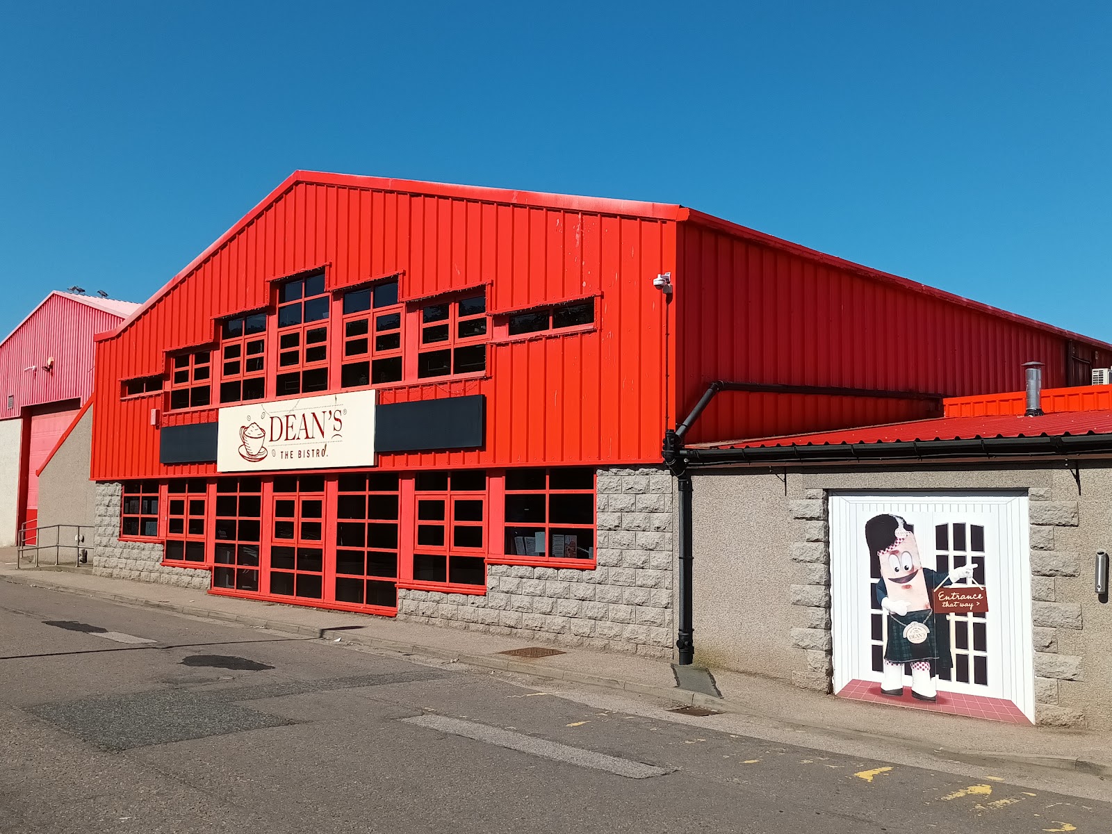 The red front of the Dean's building on Depot Road in Huntly under its name.