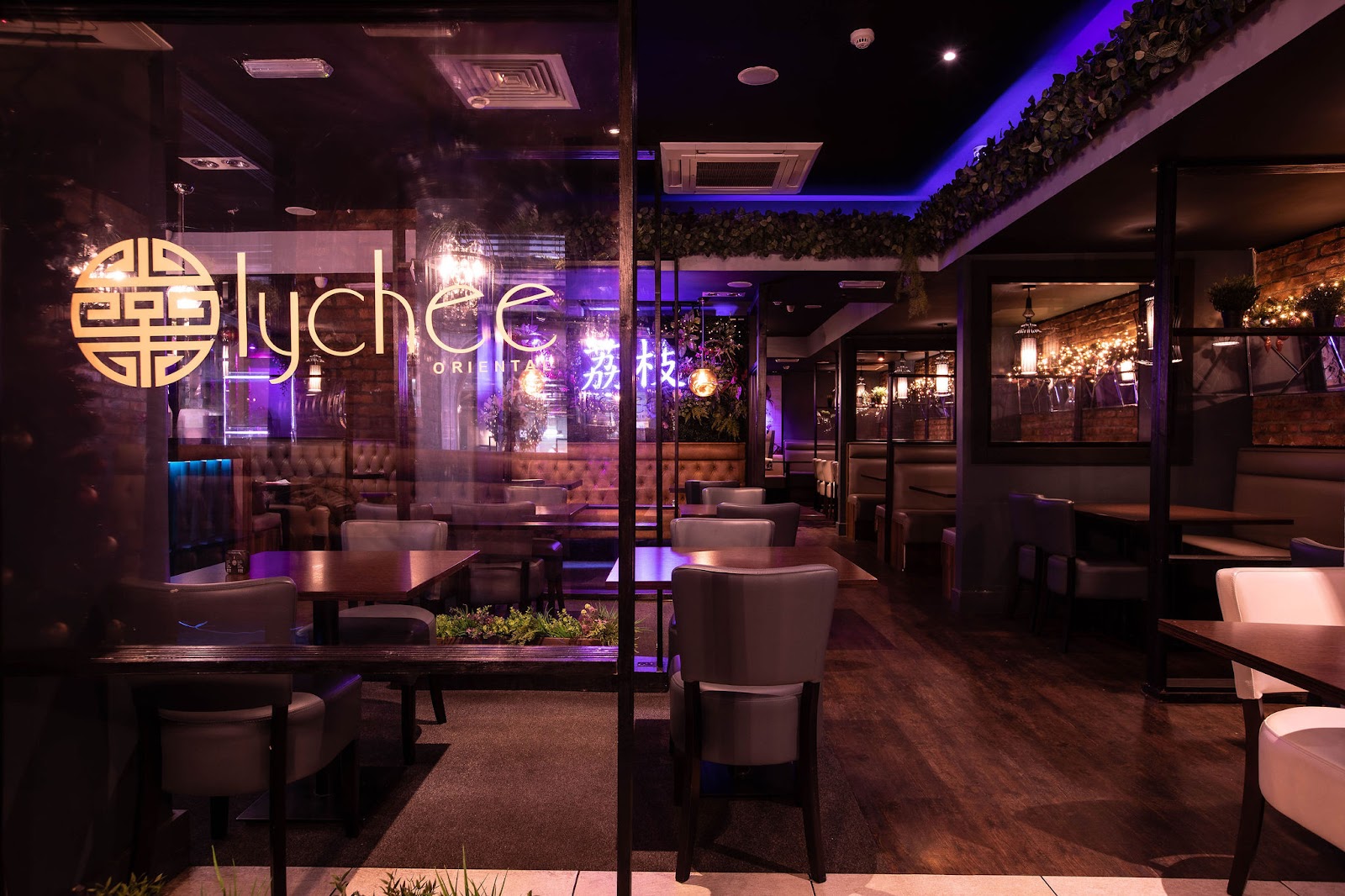 The dining room lit purple, with the Lychee logo glowing on the wall.