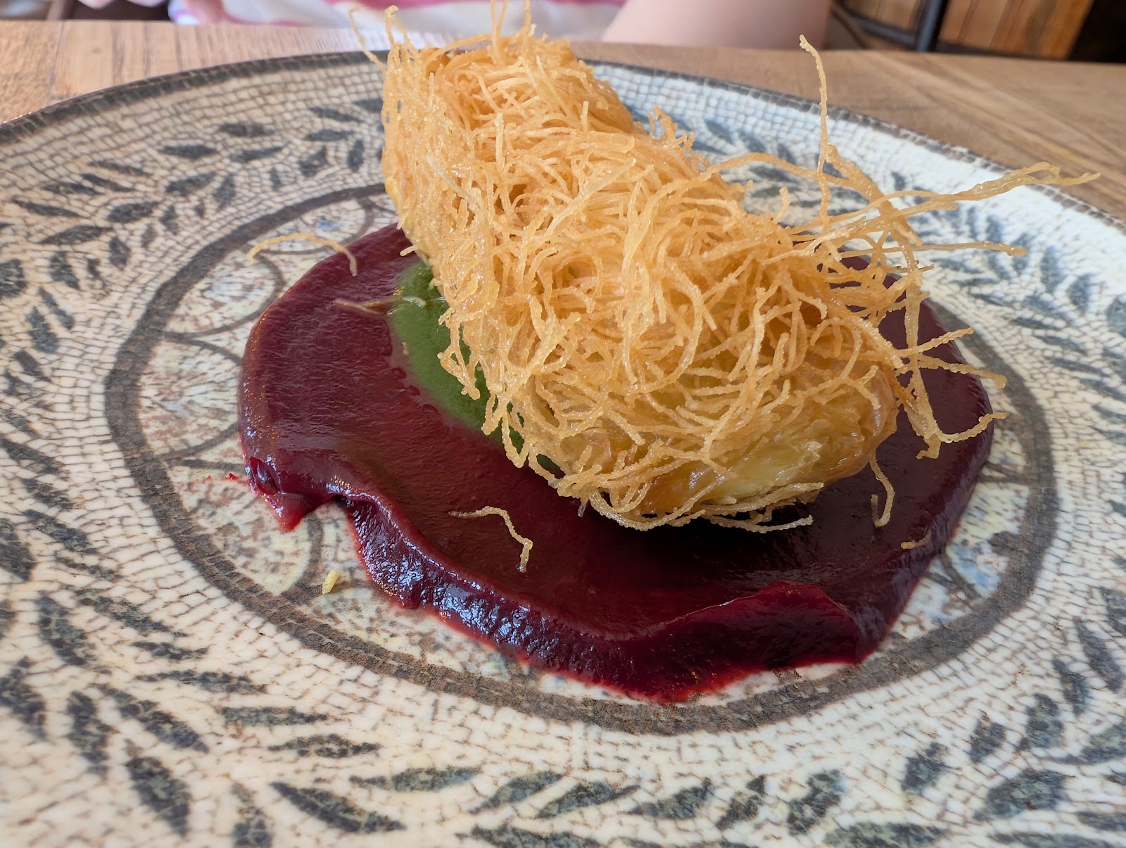 Dahi ke kebab in a nest of crisp vermicelli on beetroot ketchup and green chutney, on a patterned plate at Kalinga.