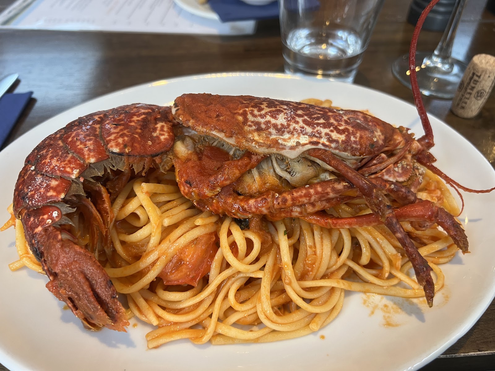 A plate of spaghetti in tomato sauce with a halved red lobster laid over it, at La Balena in Stornoway.