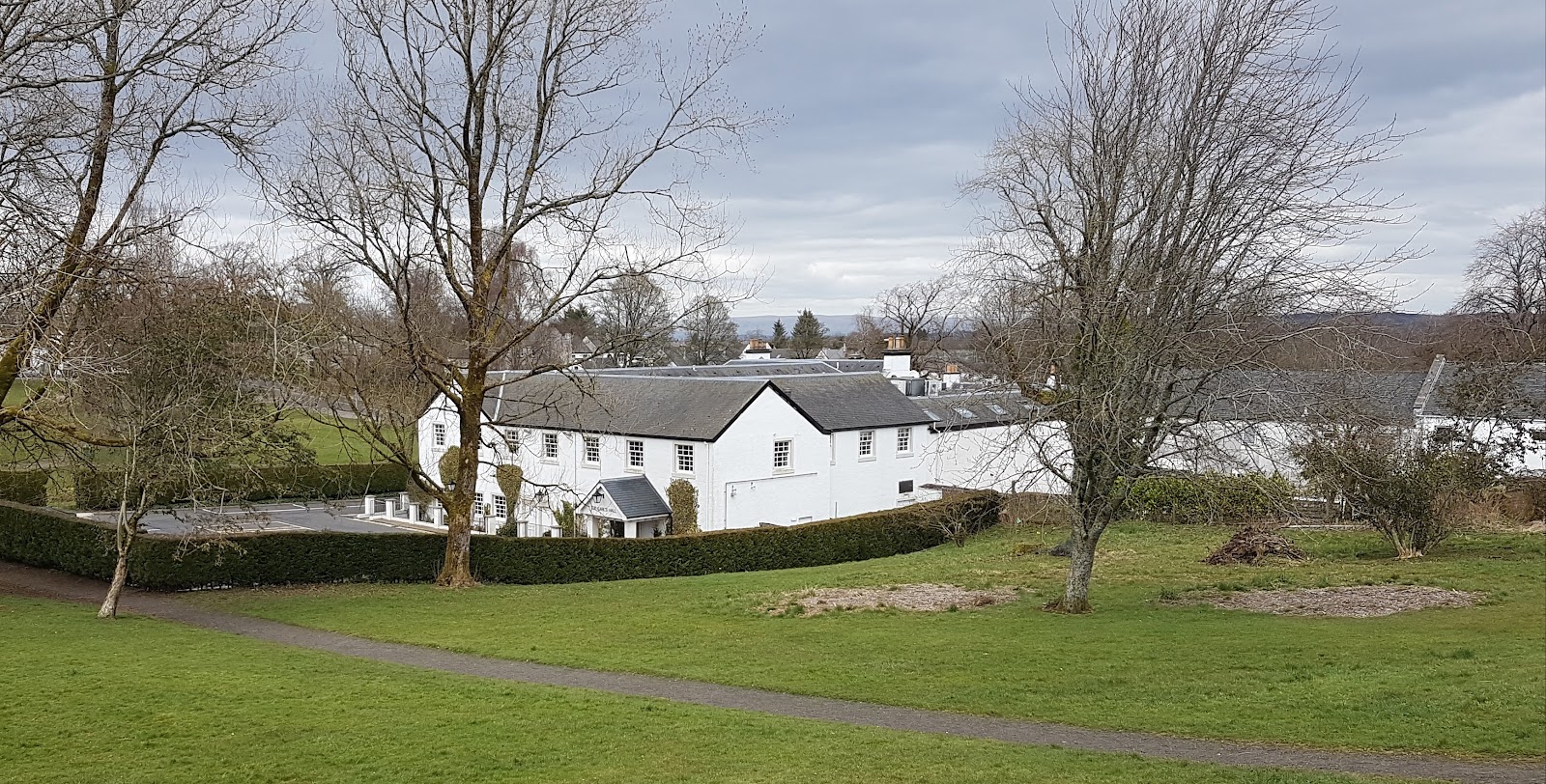 White cottages seen across the grass and bare trees of the green in Eaglesham.