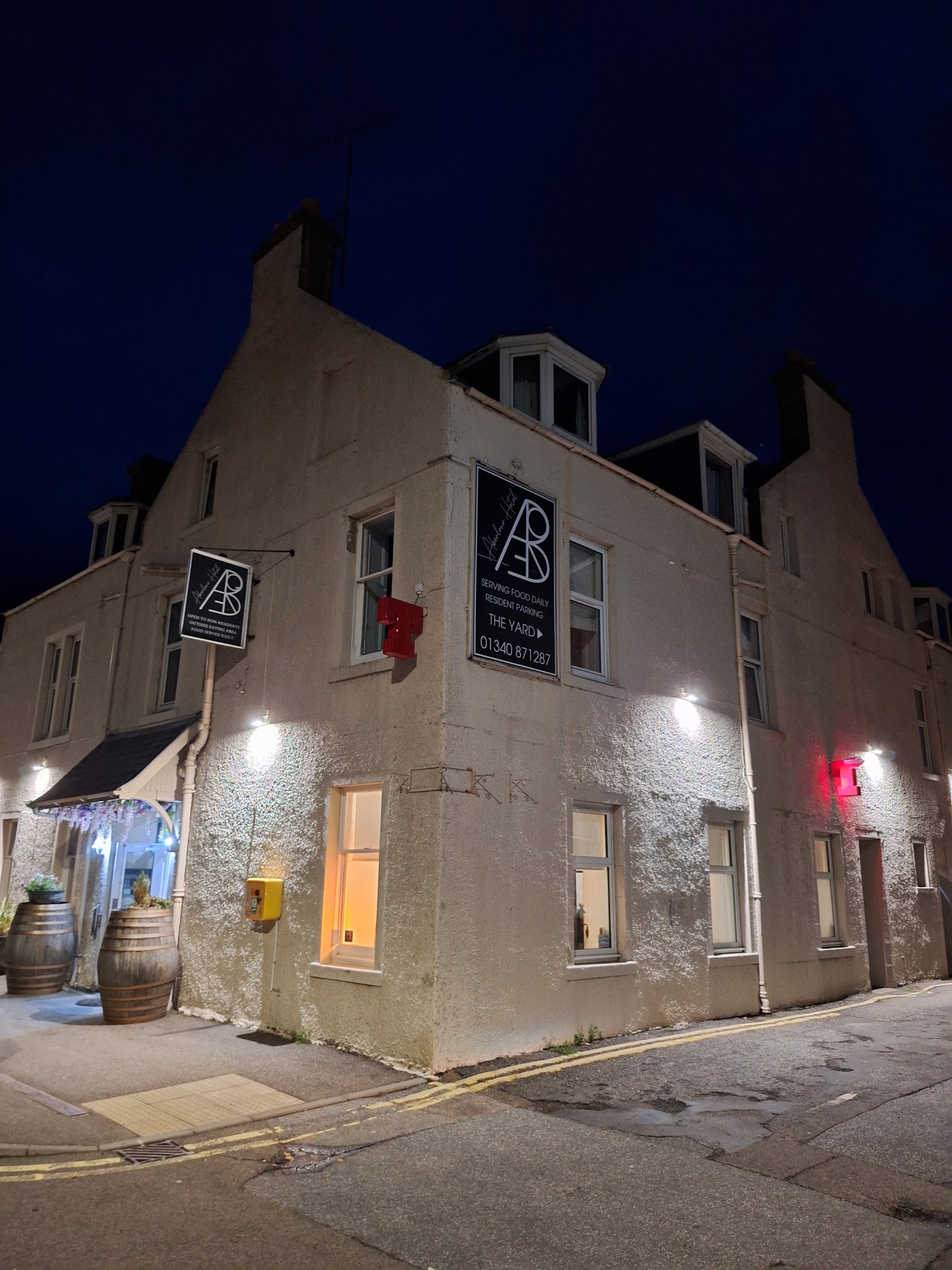 The Aberlour Hotel at dusk, its pale stone front lit up on the corner of the village square.