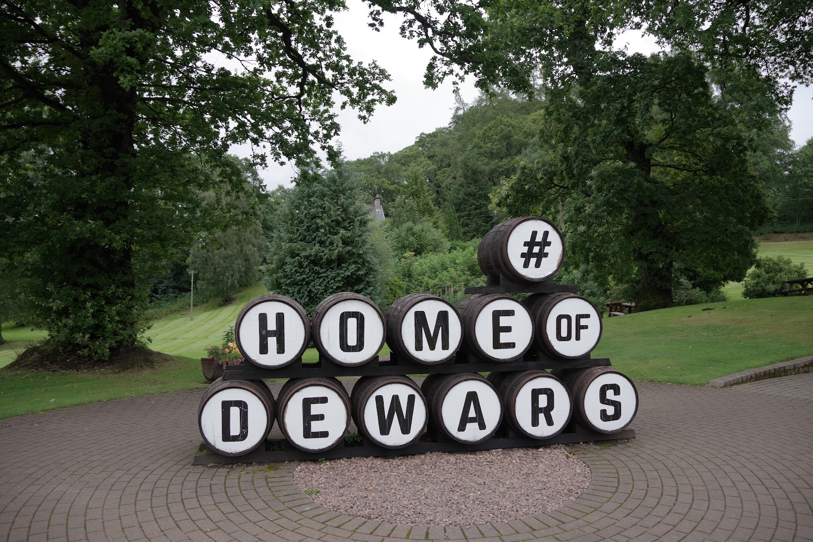 Casks spelling Home of Dewars at the distillery gate.