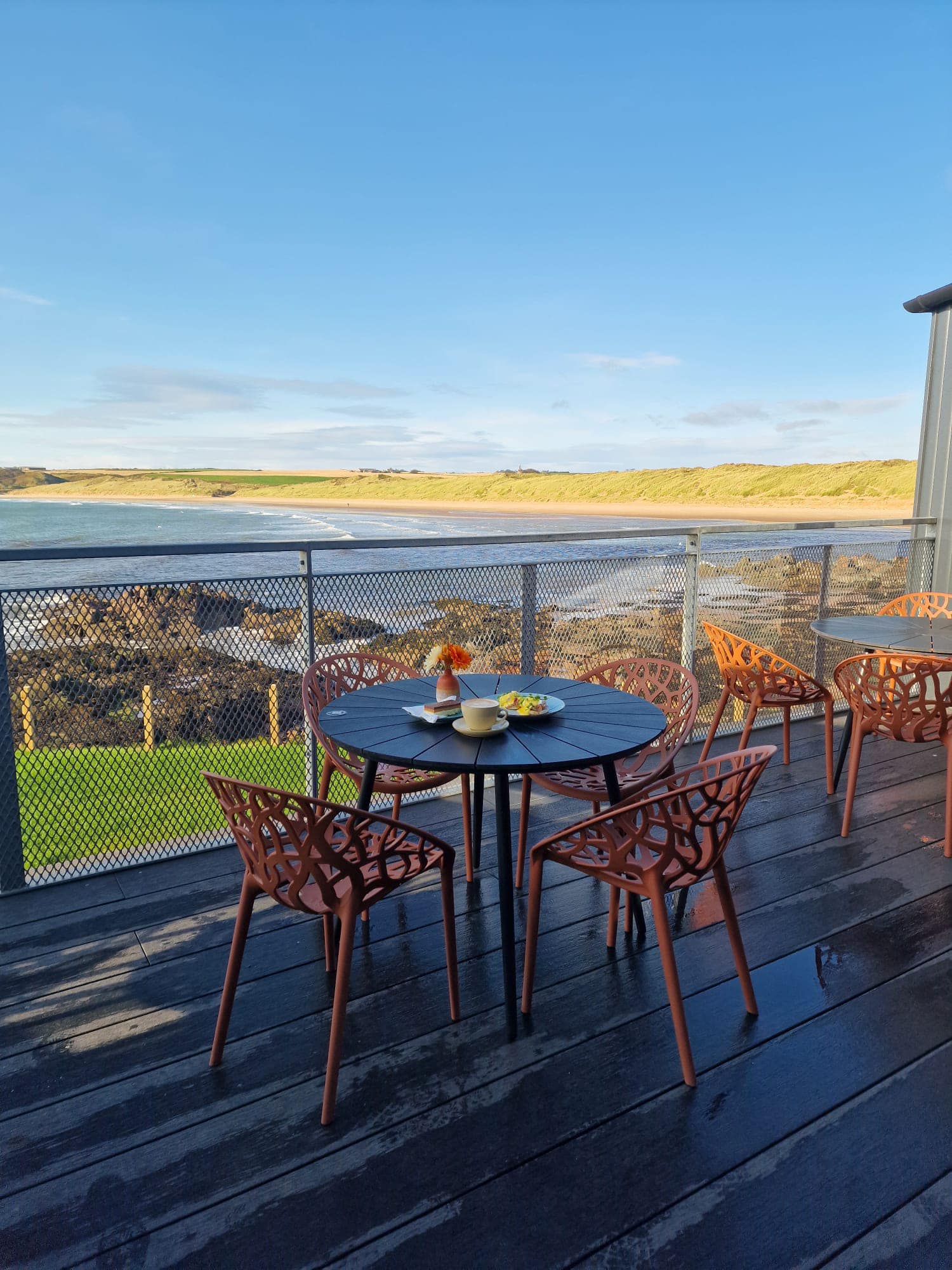 Tables on the terrace at Harbour Dunes looking over Port Erroll and the bay.