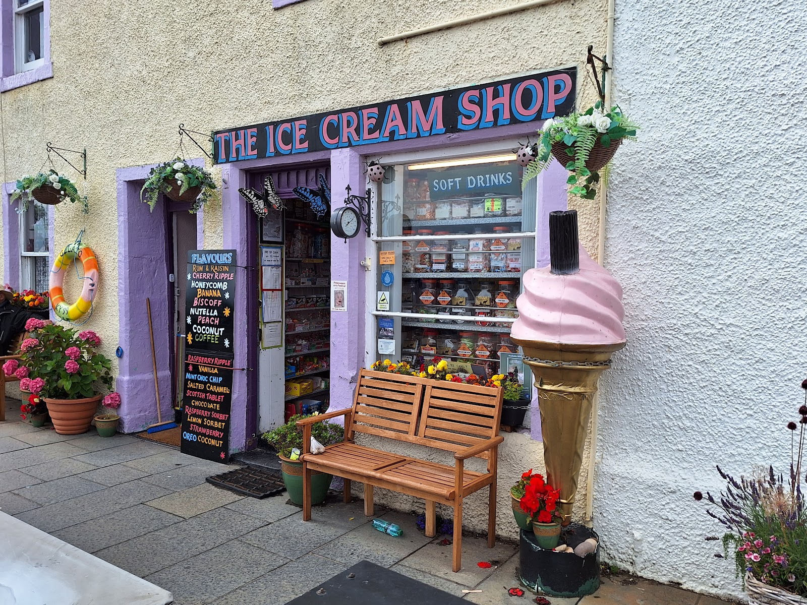 Nicholson's in Pittenweem, a purple shopfront reading Ice Cream Shop, a giant cone and flowers by the door.