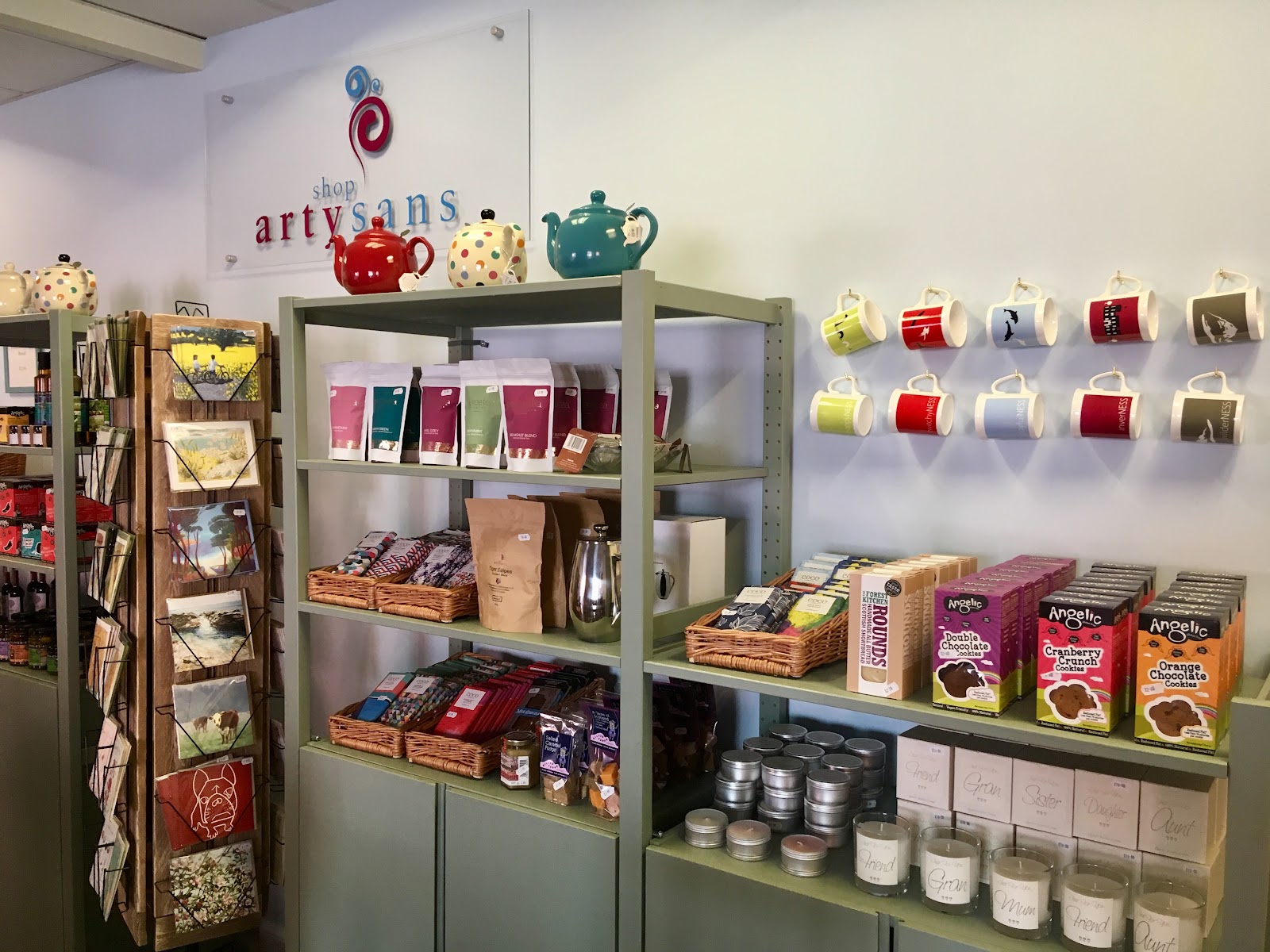 The counter at Cafe Artysans, shelves of teas and cups beneath the Artysans name on the wall.