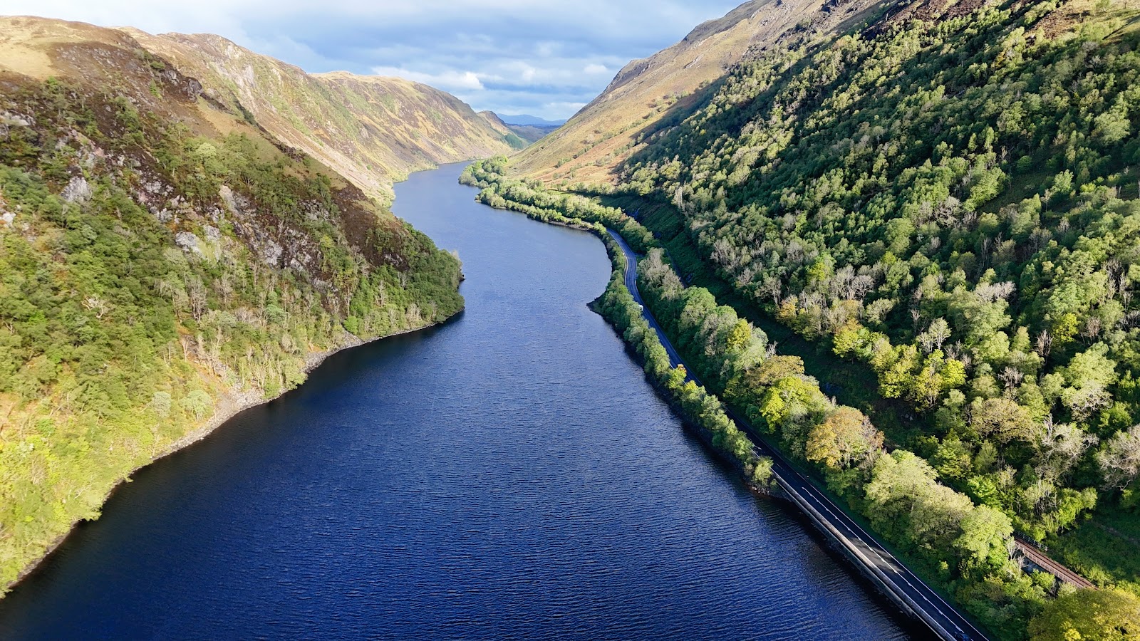 The Pass of Brander from above, its narrow water between steep wooded slopes with the road and railway along the shore.