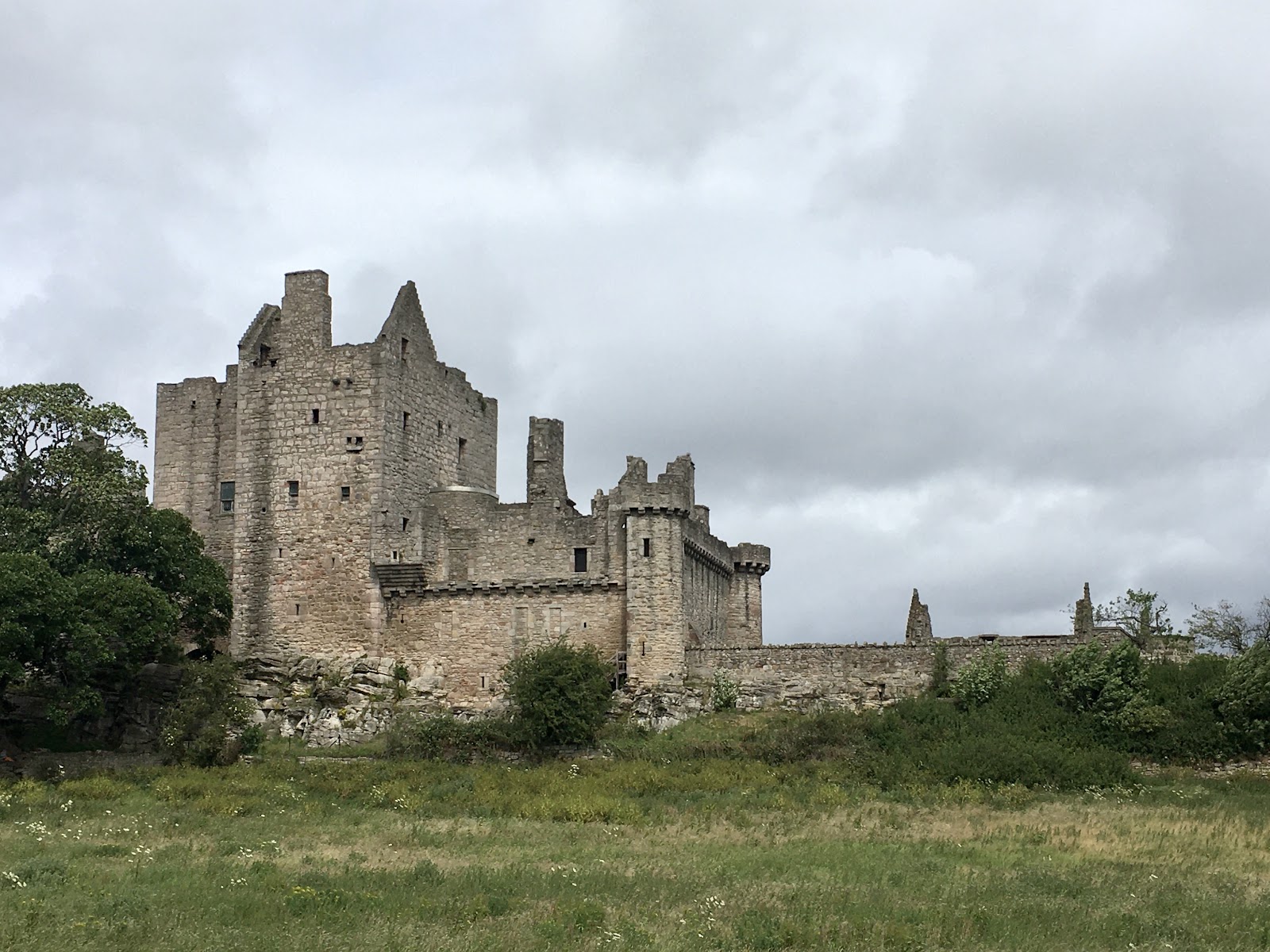 Craigmillar Castle rising above rough grass in Craigmillar Castle Park.
