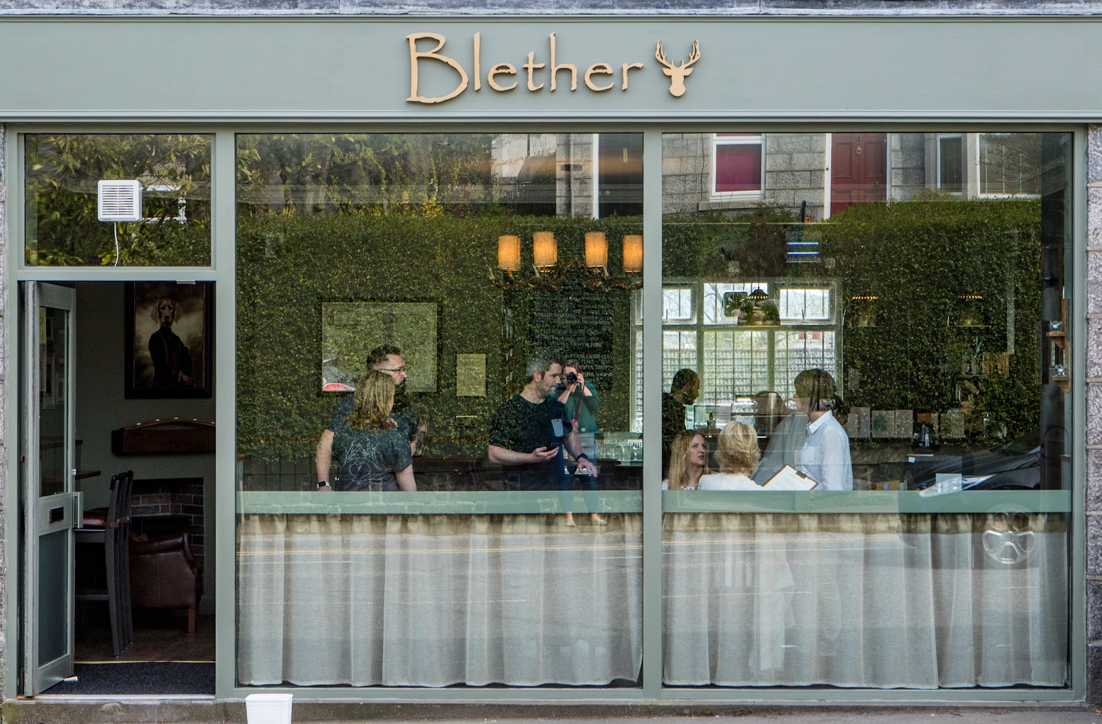The front of Blether on North Deeside Road in Cults, its name over a wide window and people chatting inside.