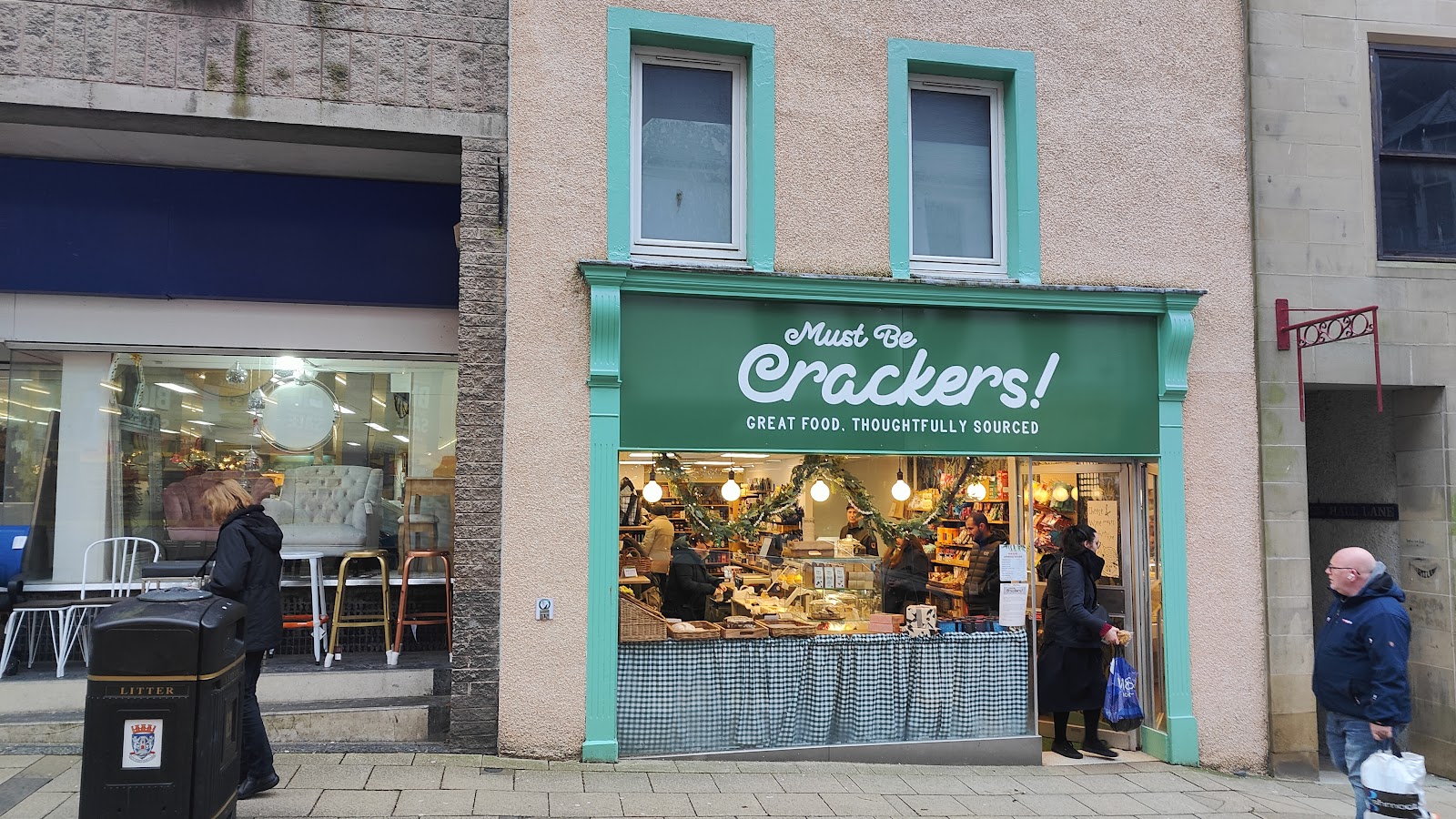 The green shopfront of Must Be Crackers! on Dunfermline High Street, its counter and shelves seen through the open door.