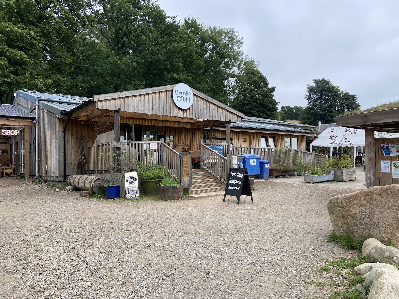 The farm shop and yard at Comrie Croft among the trees.