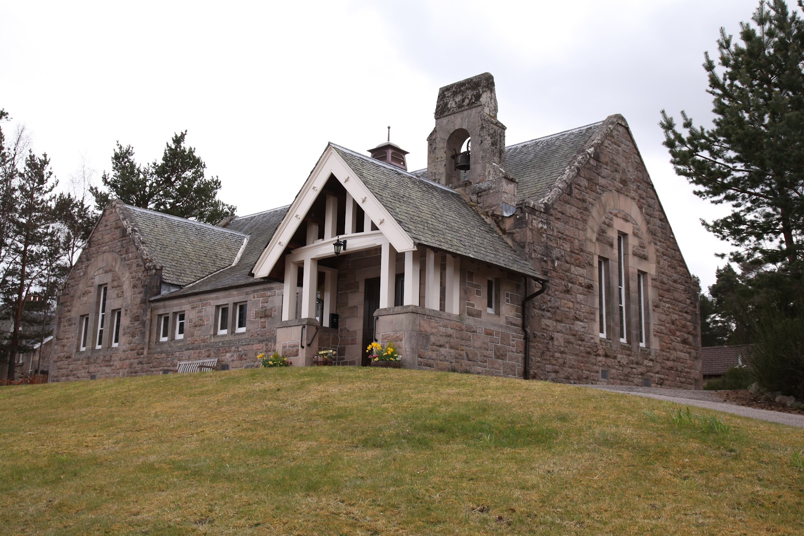 Duthil Old Parish Church in its churchyard among pines.