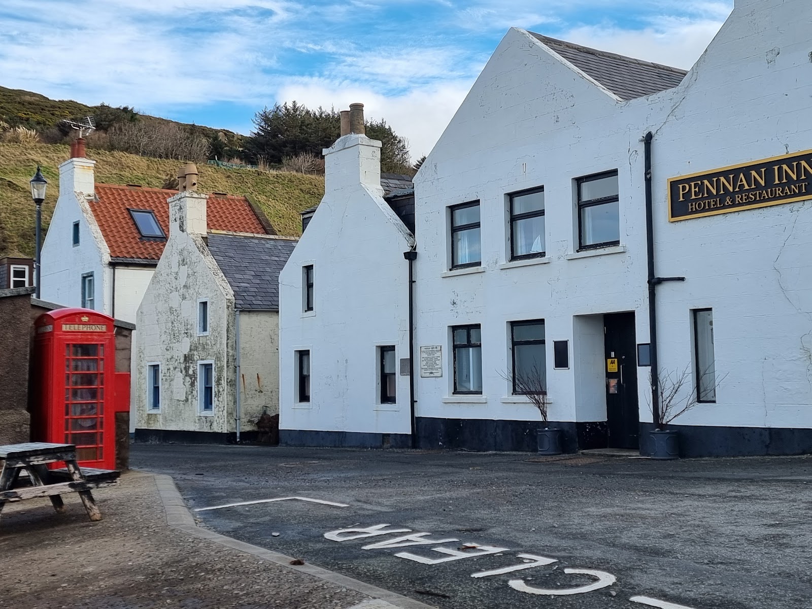 The whitewashed row of Pennan below the cliffs, the red phone box by the inn.