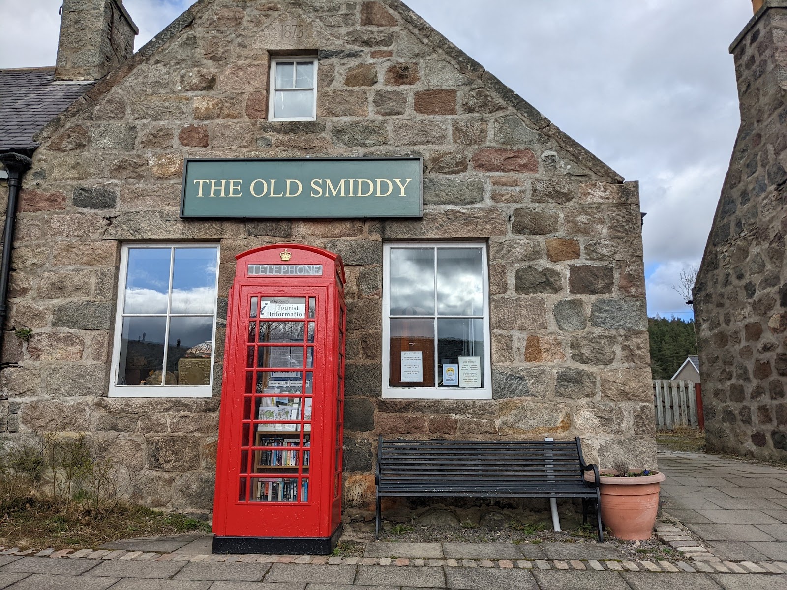 The stone front of the Old Smiddy with a red telephone box outside.