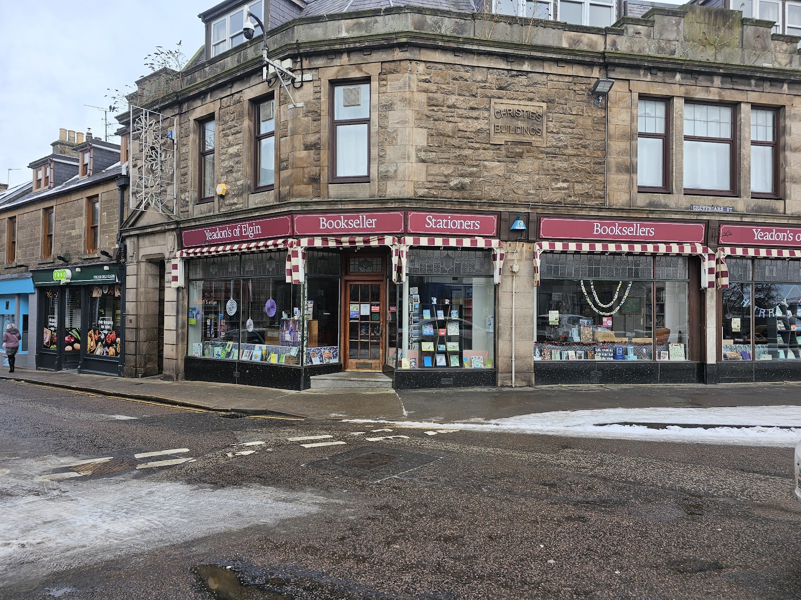 Yeadon's on a corner of Commerce Street in Elgin, red and white striped awnings over windows lettered booksellers and stationers.
