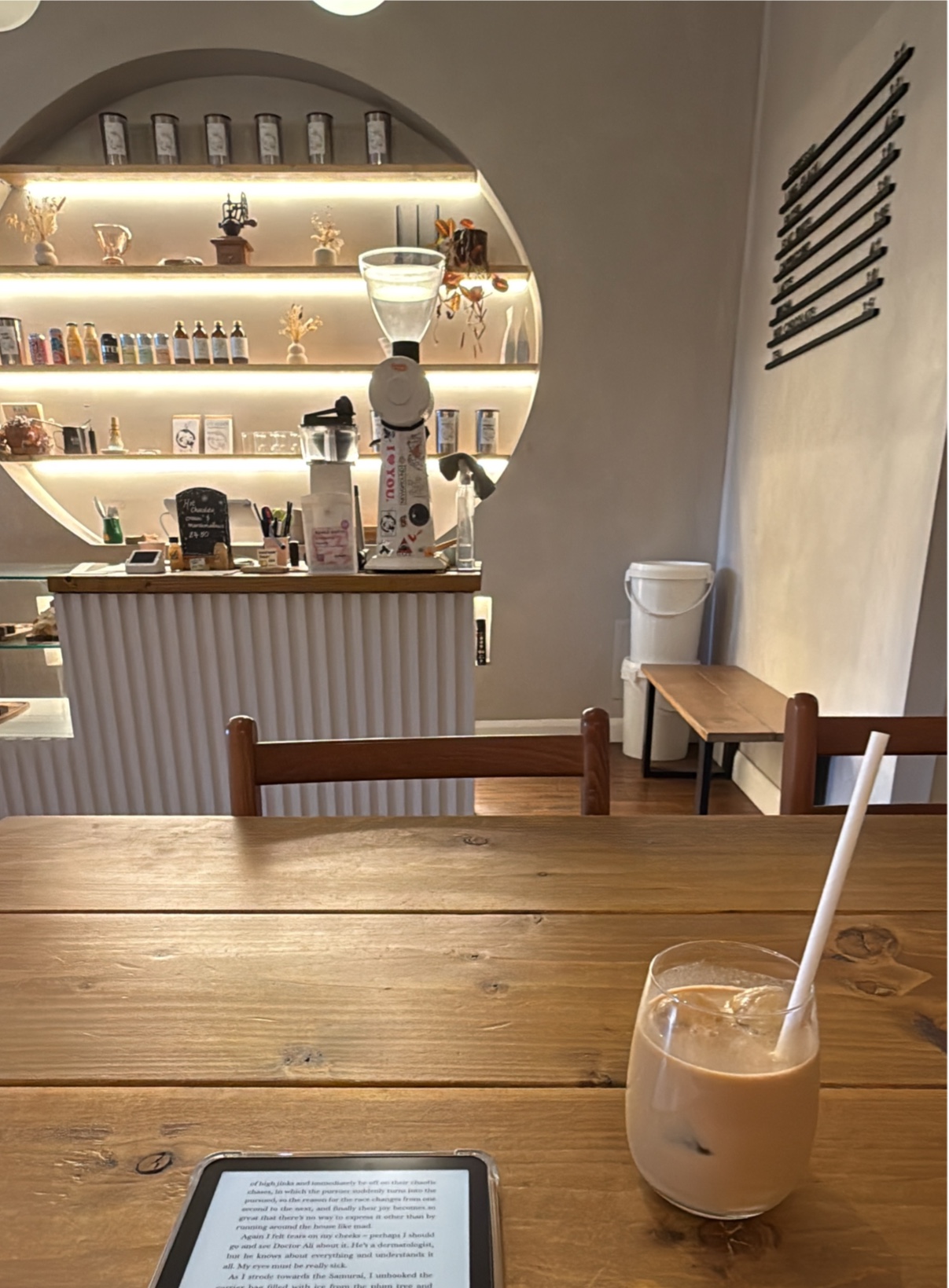 Inside Höfn on Bank Street, Dundee: the counter in front of lit shelves set into a round arch, seen across a wooden table.