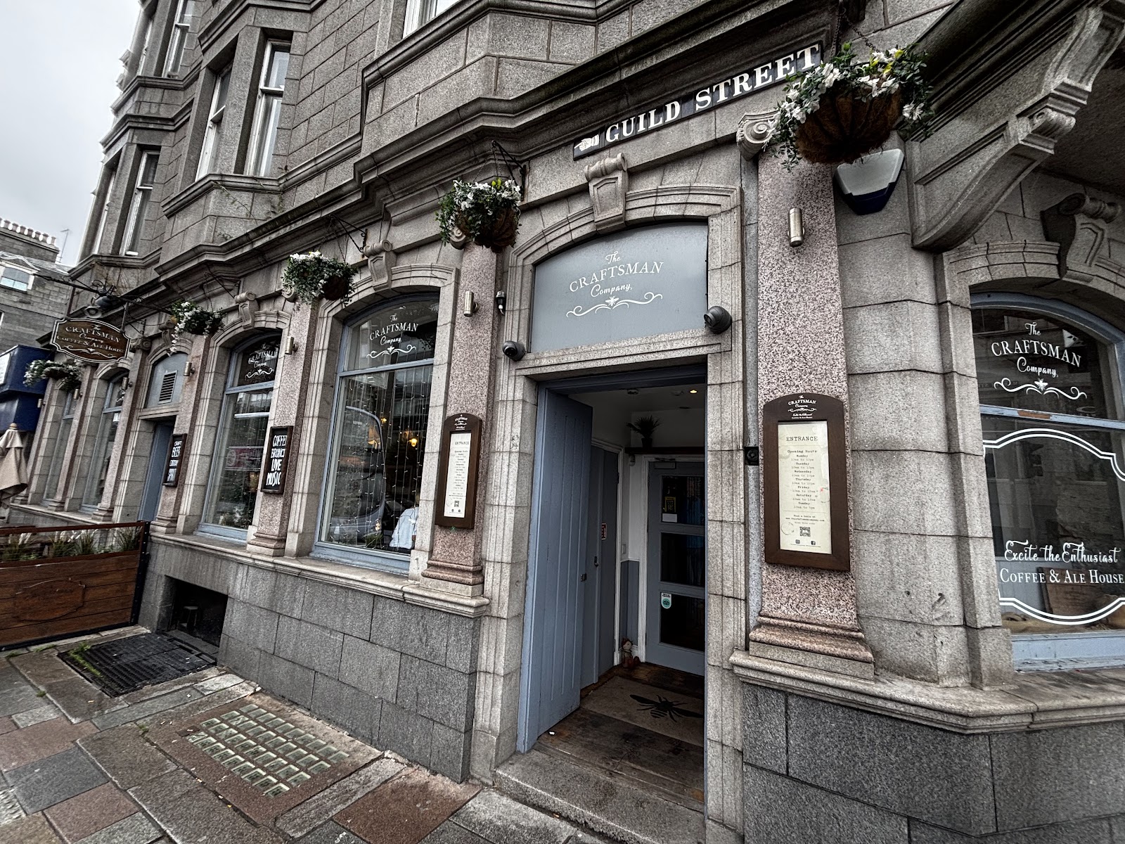 The granite front of the Craftsman Company on the corner of Guild Street, its door open and its name in the windows.