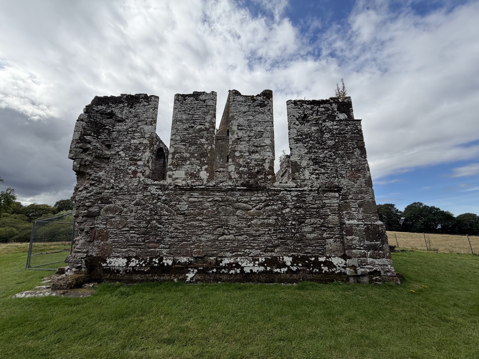 The ruined church and tower of Restenneth Priory on the grass.