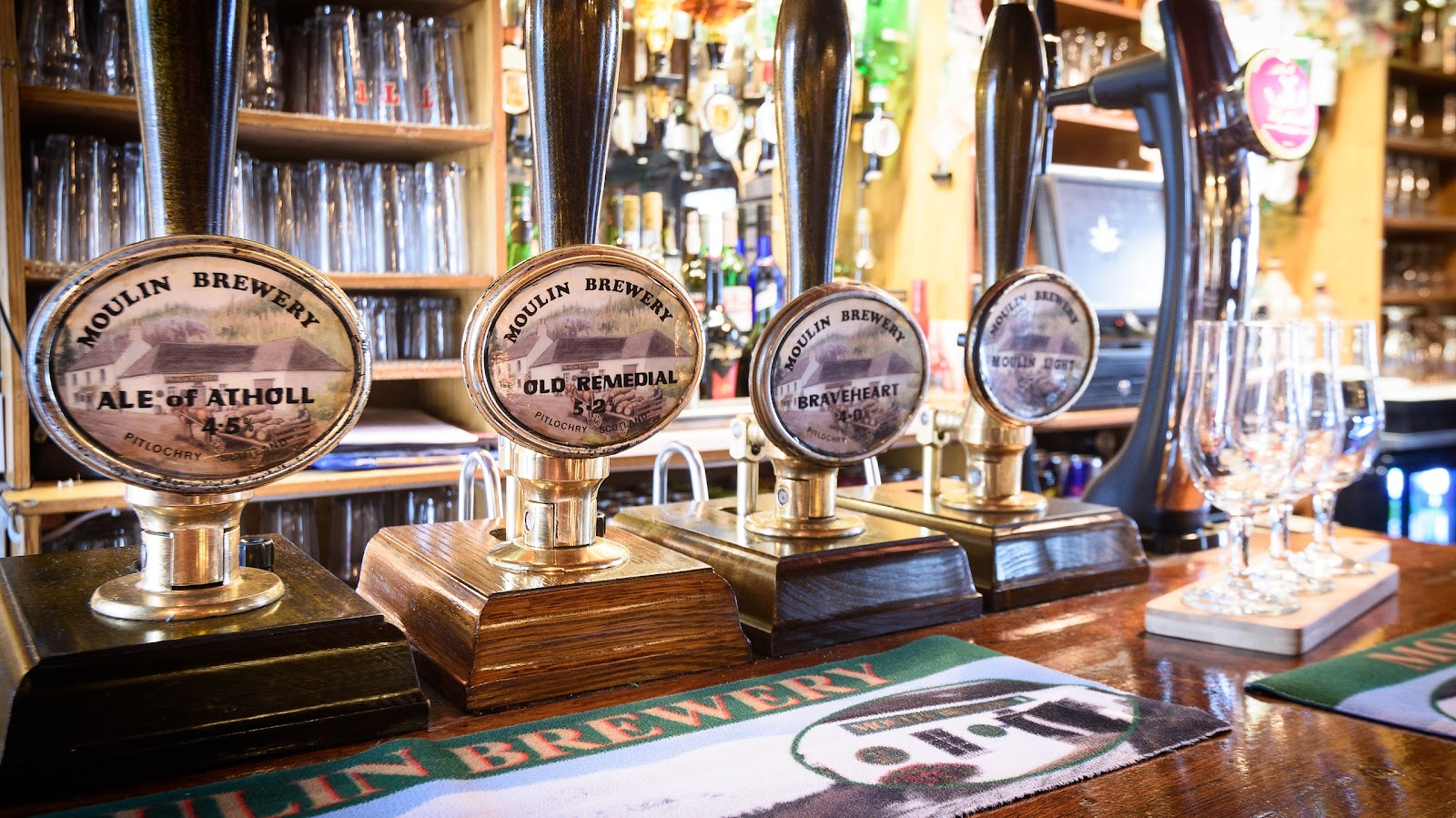 Brass beer pumps of the Moulin Brewery's own ales on the bar.