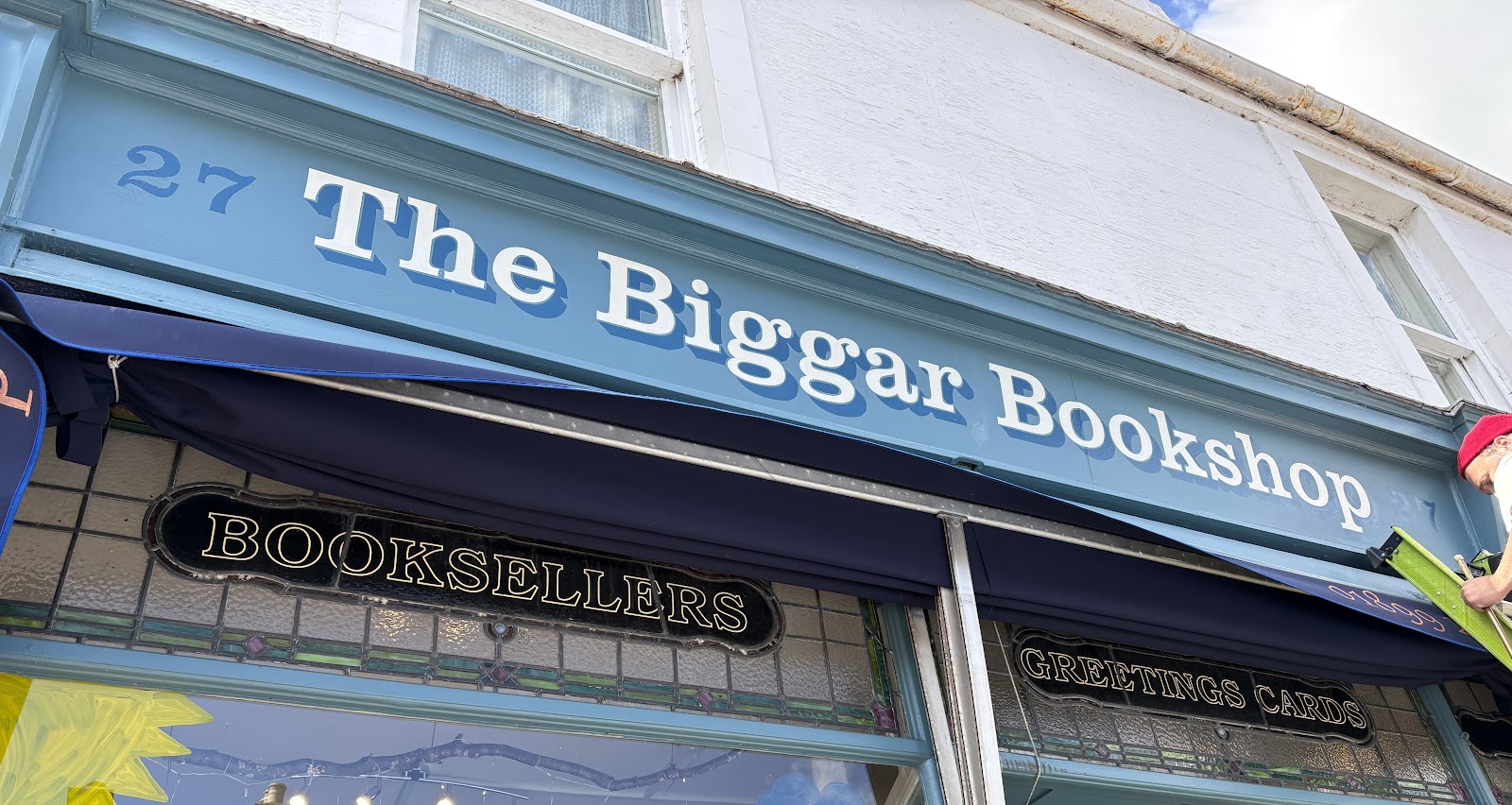 The Biggar Bookshop on the High Street in Biggar, a blue painted shopfront with books in the window.