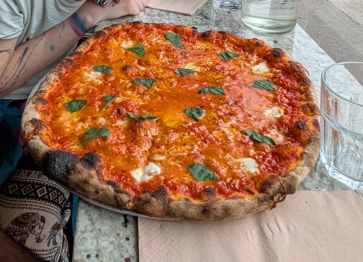 A margherita pizza with buffalo mozzarella and basil on a marble table at Errol's Hot Pizza.
