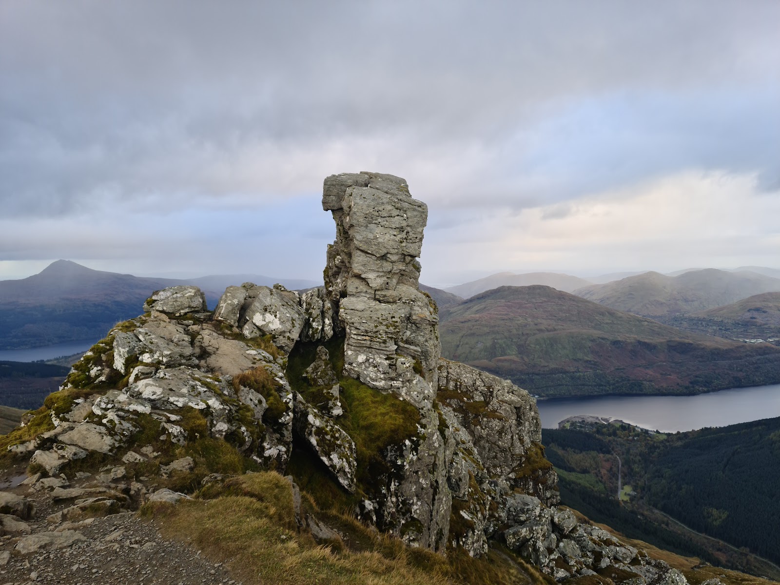 The Cobbler's summit rock above a loch, the Arrochar hills beyond.