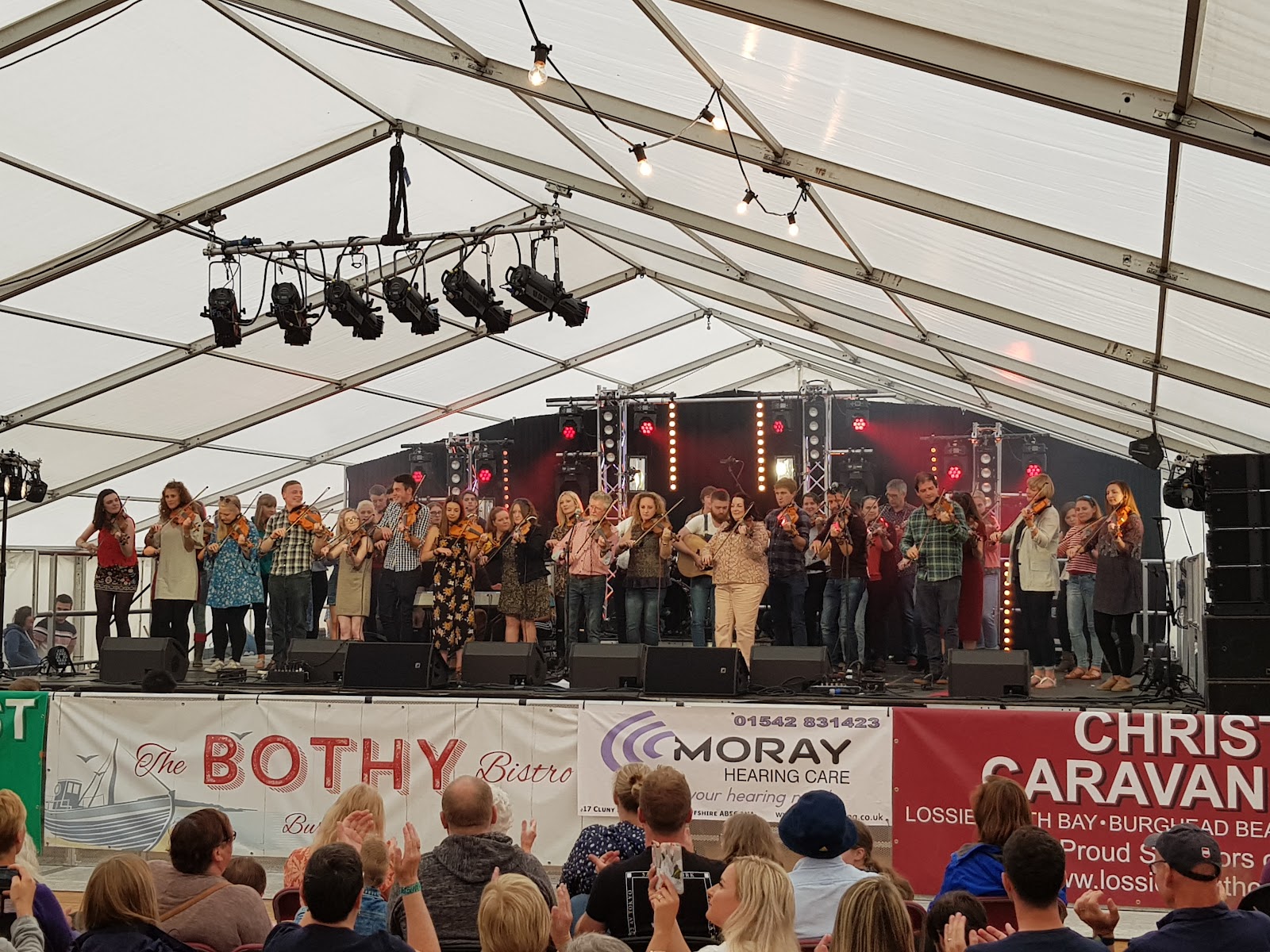 A Speyfest ceilidh stage inside the big tent at Fochabers, musicians and dancers under the lights.