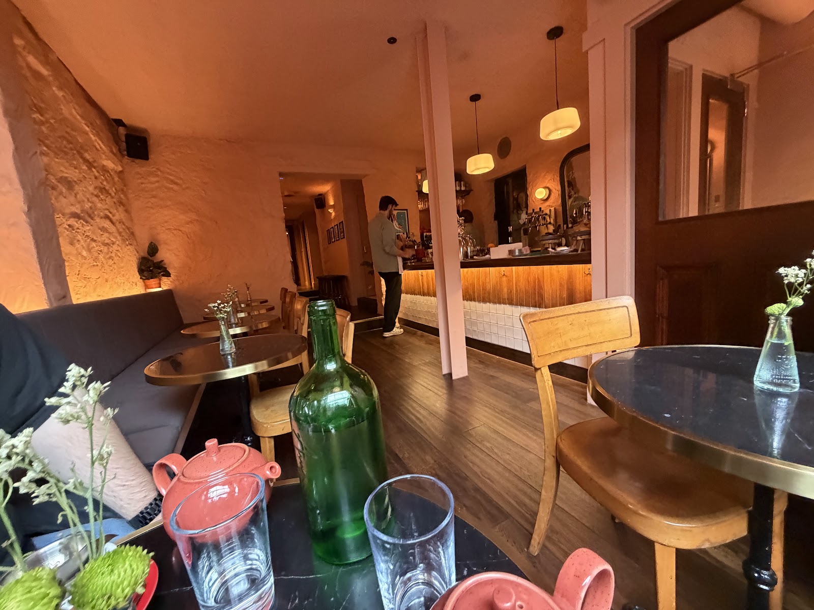 The basement room at Capetto under Little Capo, with a long banquette, small brass-edged tables and the bar lit warm at the far end.