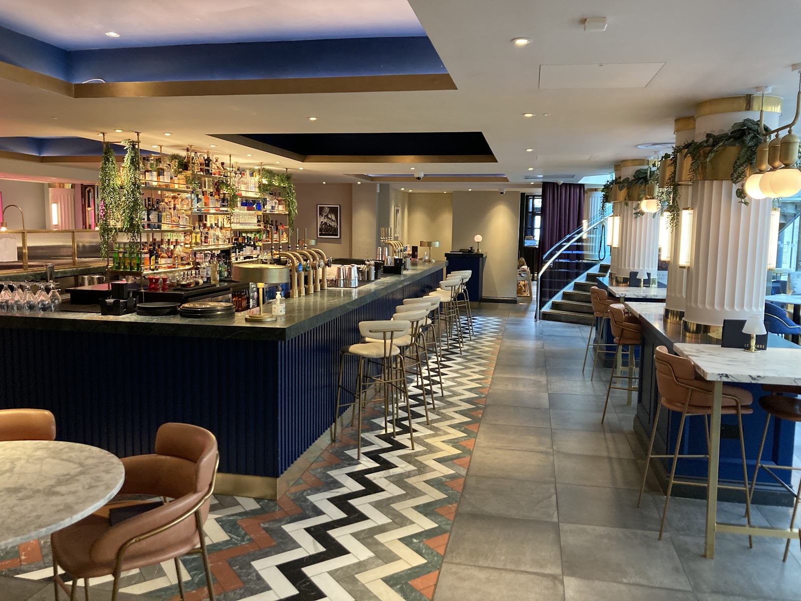The long bar at Le Monde on George Street, above a chevron floor.