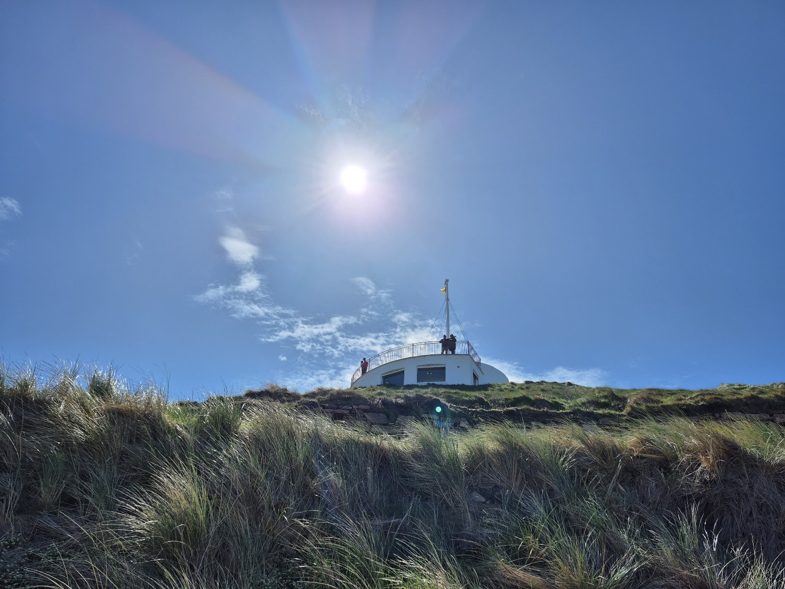 The round white visitor centre on the Burghead headland, set in rough grass under a bright sky.