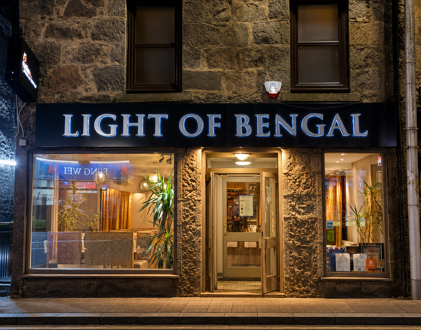 Light of Bengal's front on Rose Street at night, its name lit above a window into the dining room and an open door.