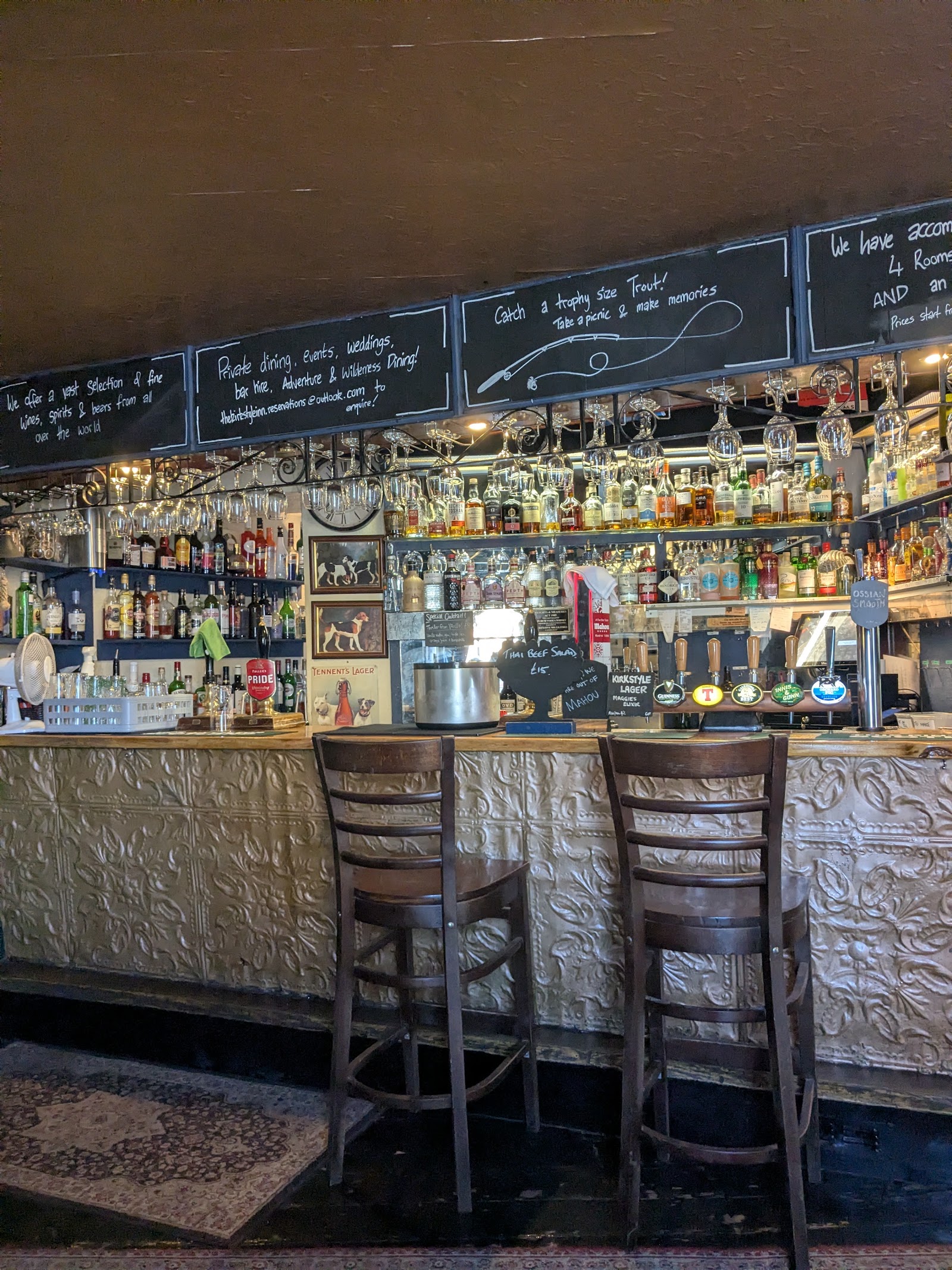 The bar of the Kirkstyle Inn, its gantry of bottles and stools.