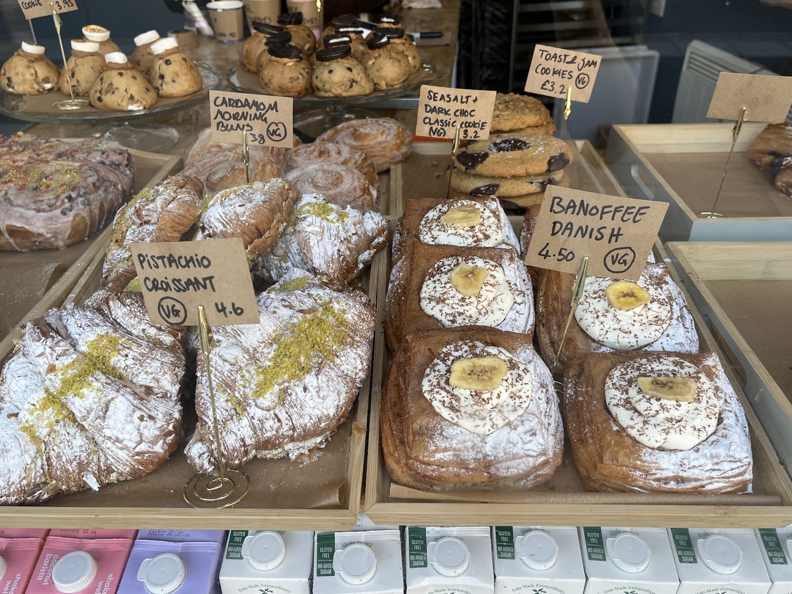 Trays of pastries on the counter at the Babyfaced Baker, among them pistachio croissants, banoffee danishes, cardamom buns and sea salt dark chocolate cookies.